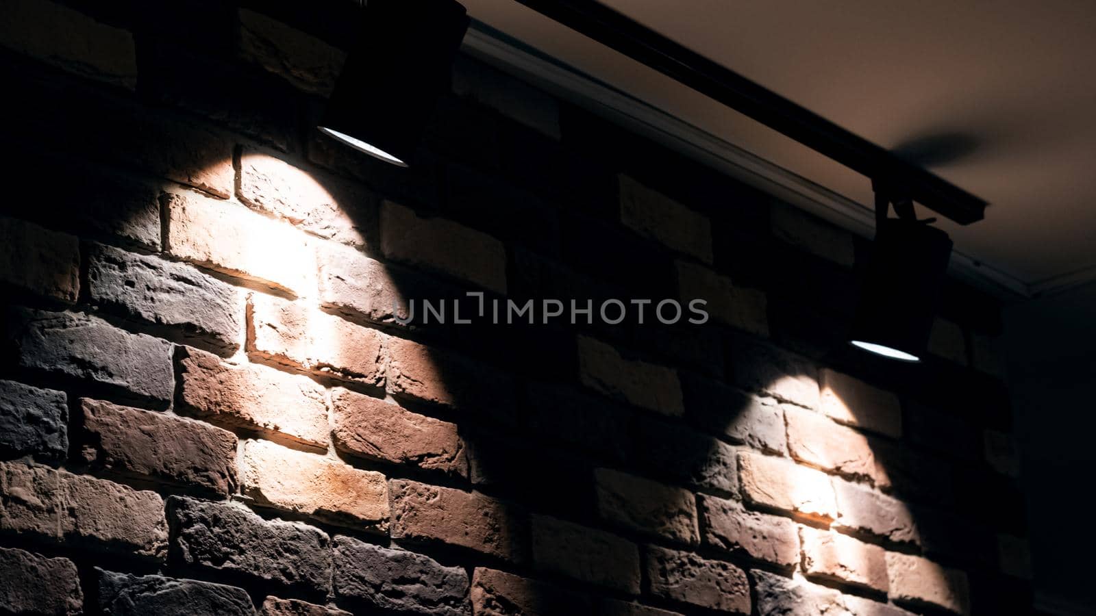 Two bright lamps on a red brick wall indoor close up