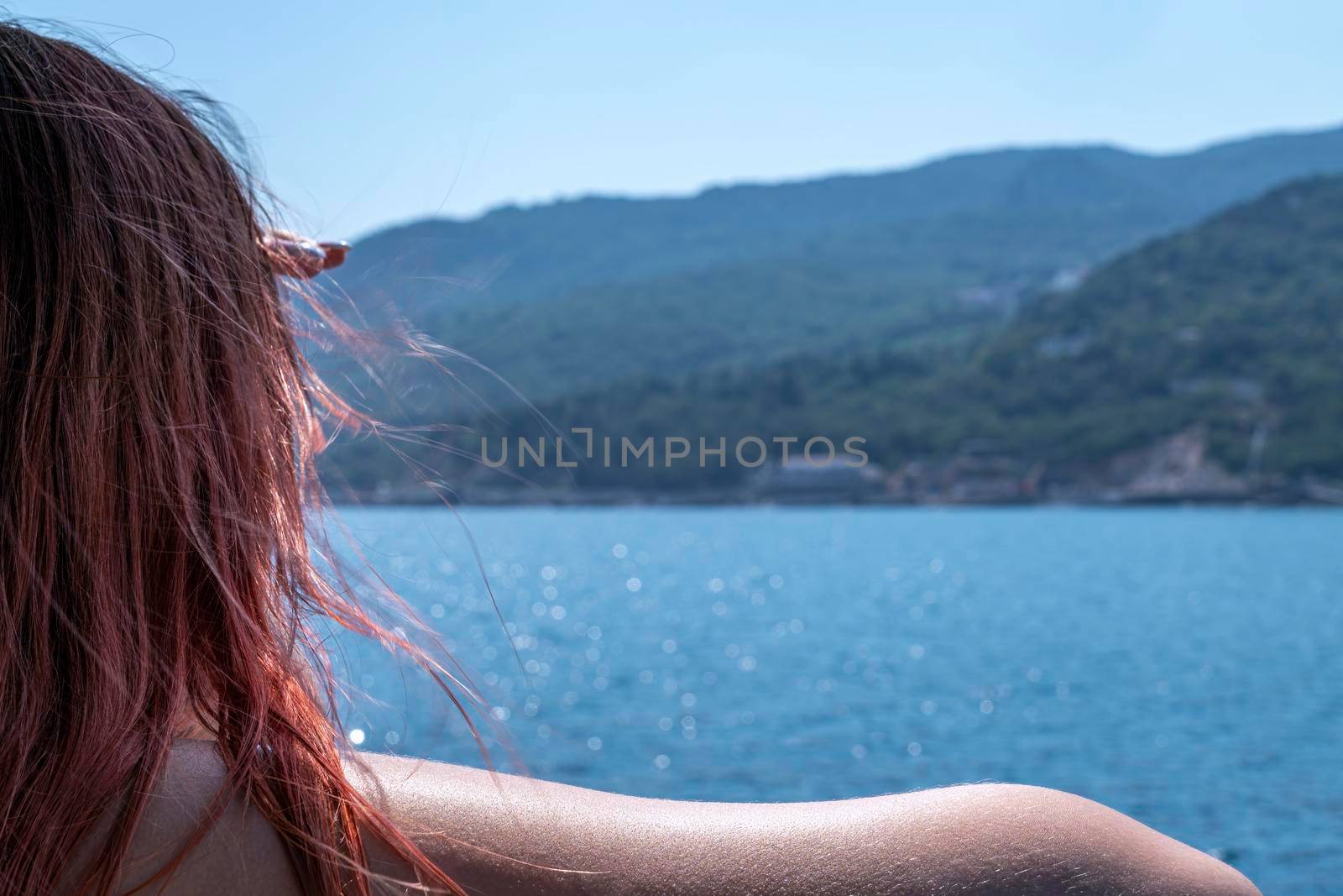 a young woman looks at the shore from a ship. High quality photo