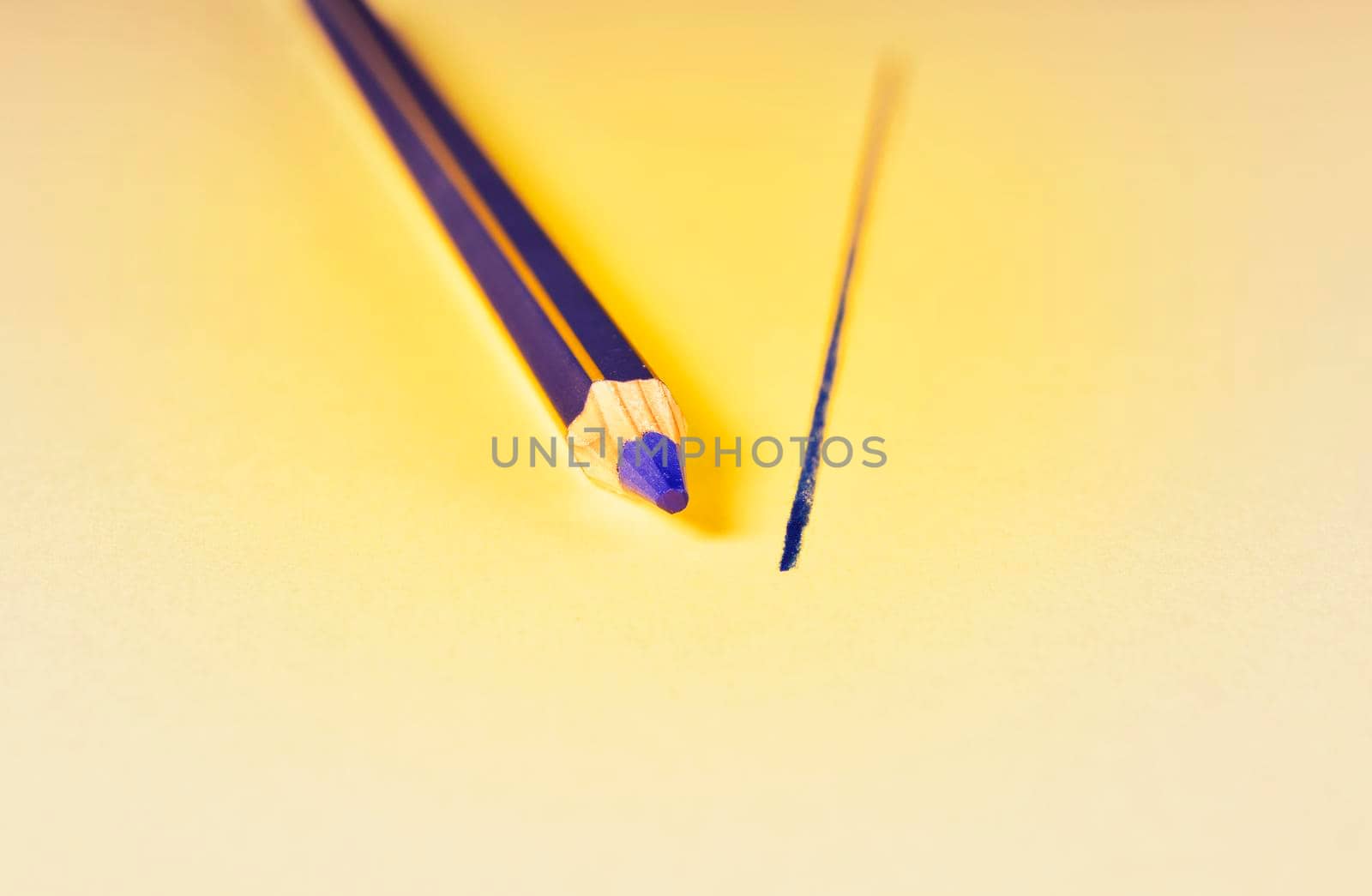 One blue wooden pencil and blue line on yellow background