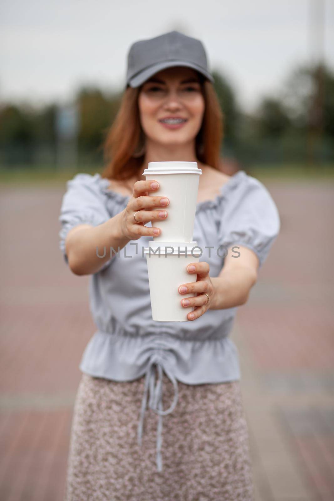 Two white paper cup with coffee in woman hand. Time for drink coffee by AnatoliiFoto