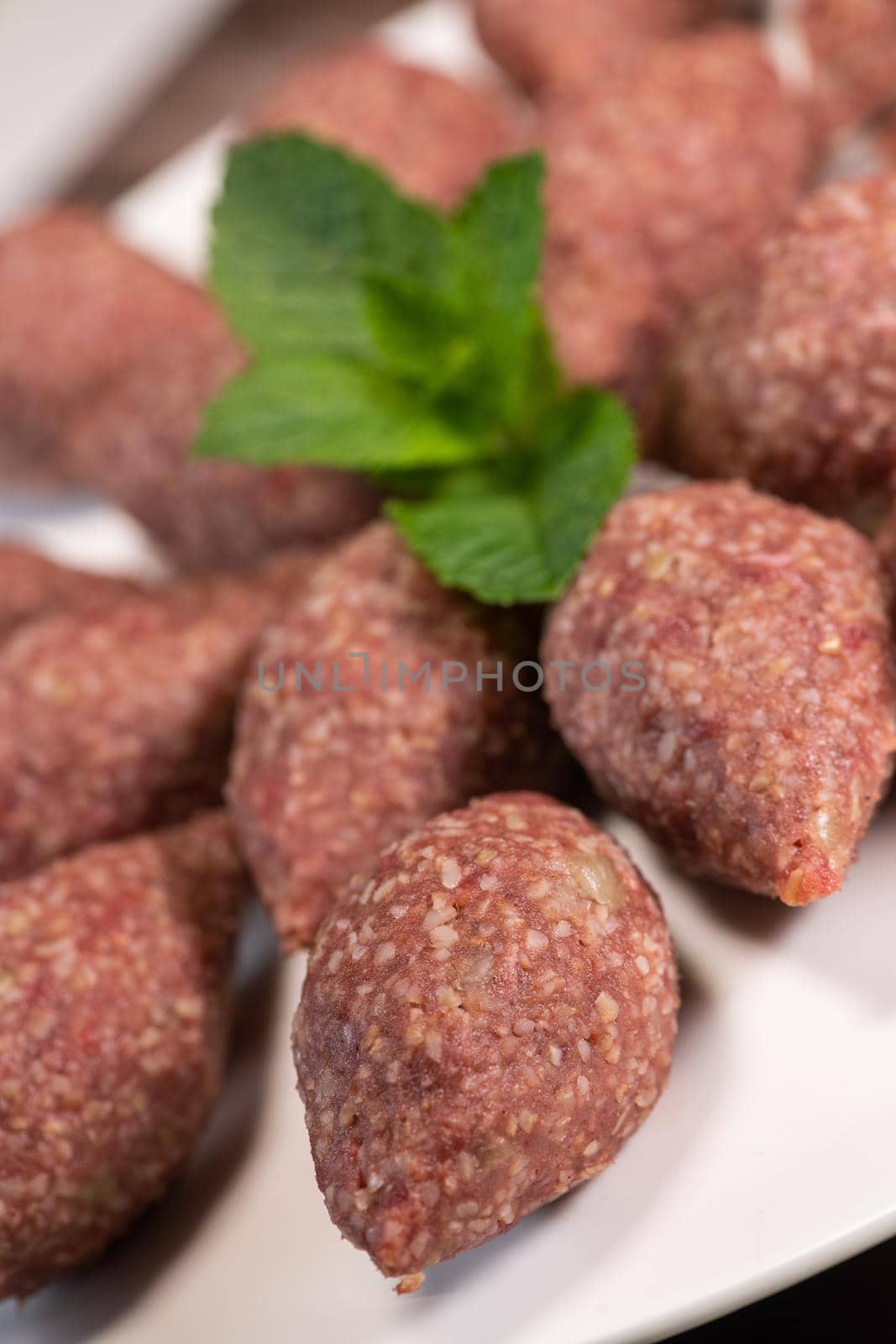 Traditional kebbe and pita bread on big round plate in lebanese restaurant. High quality photo