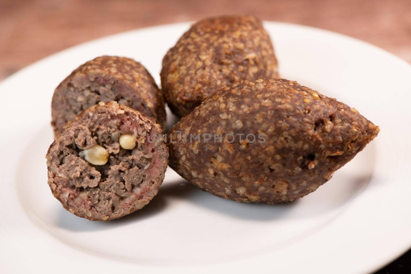 Traditional kebbe and pita bread on big round plate in lebanese restaurant. High quality photo