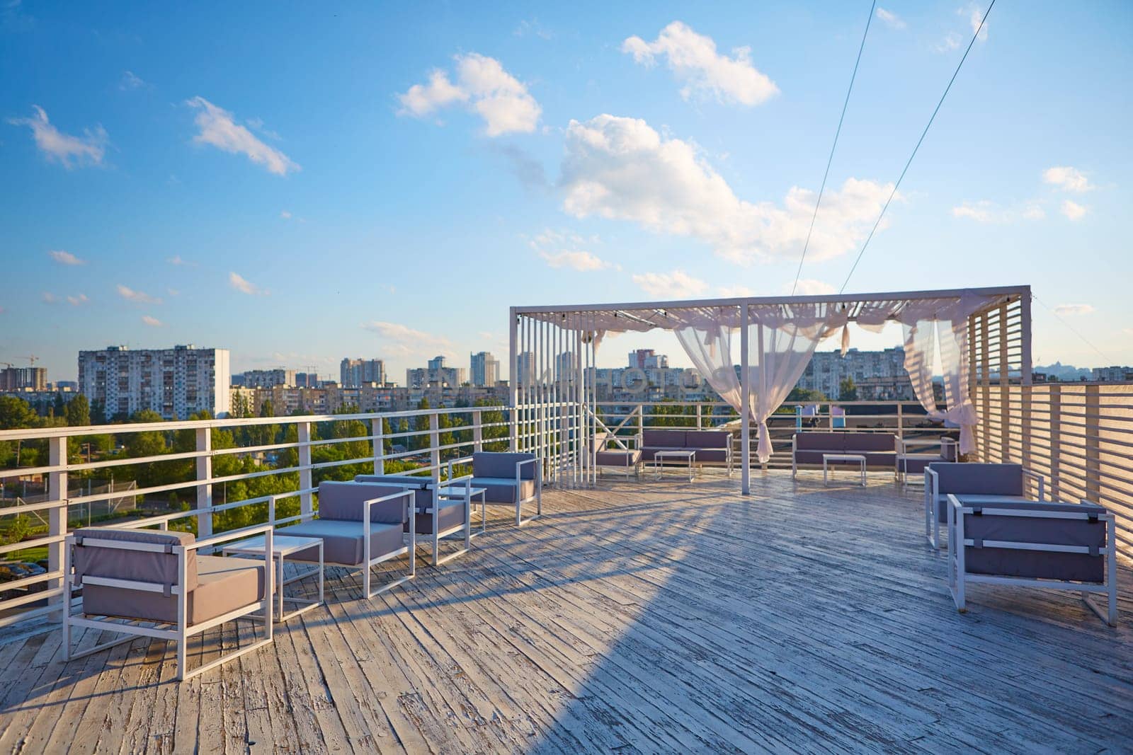 Rooftop cafe, open terrace with wooden tables.