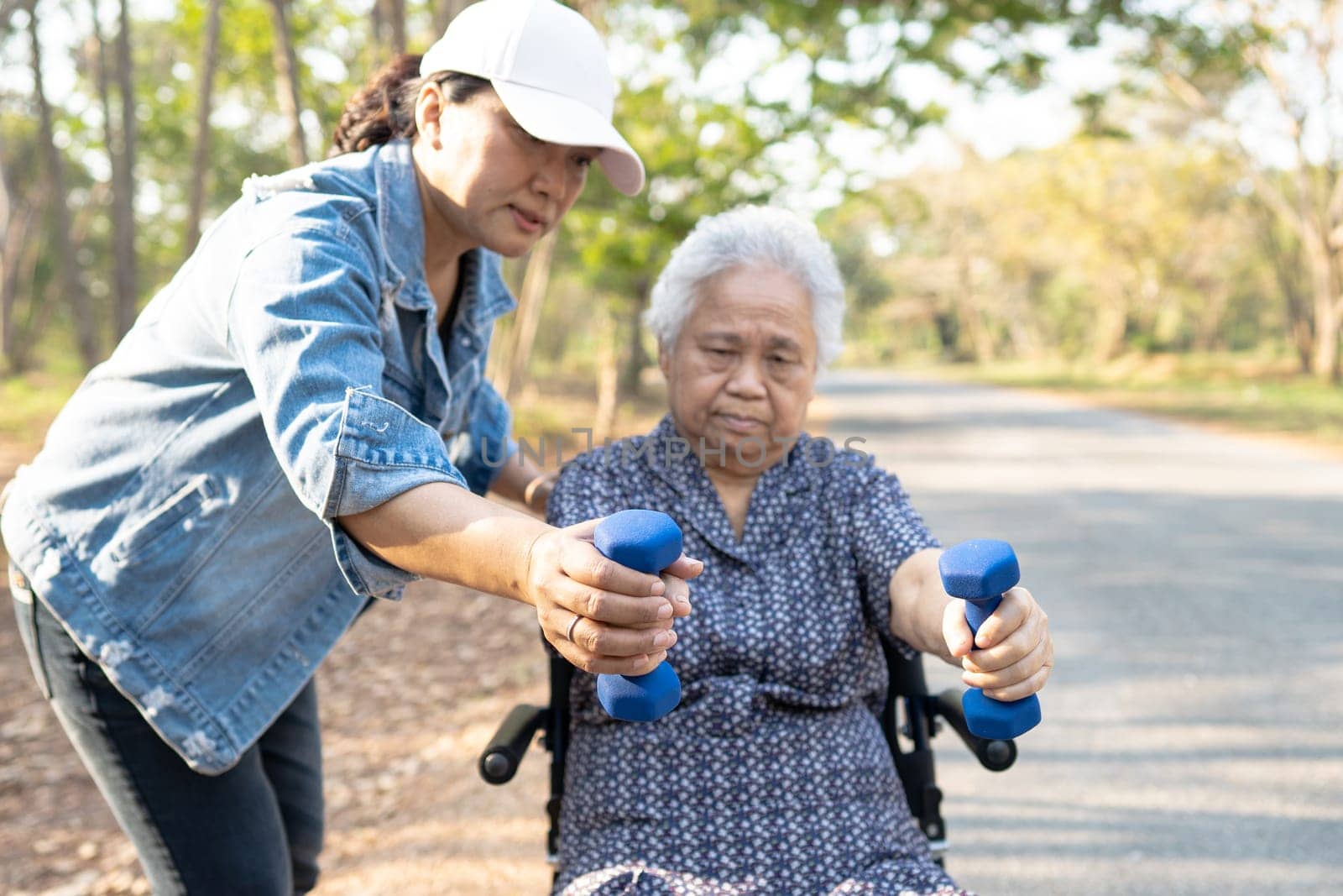 Asian elderly woman exercise with dumbbell in park, healthy strong medical concept. by pamai