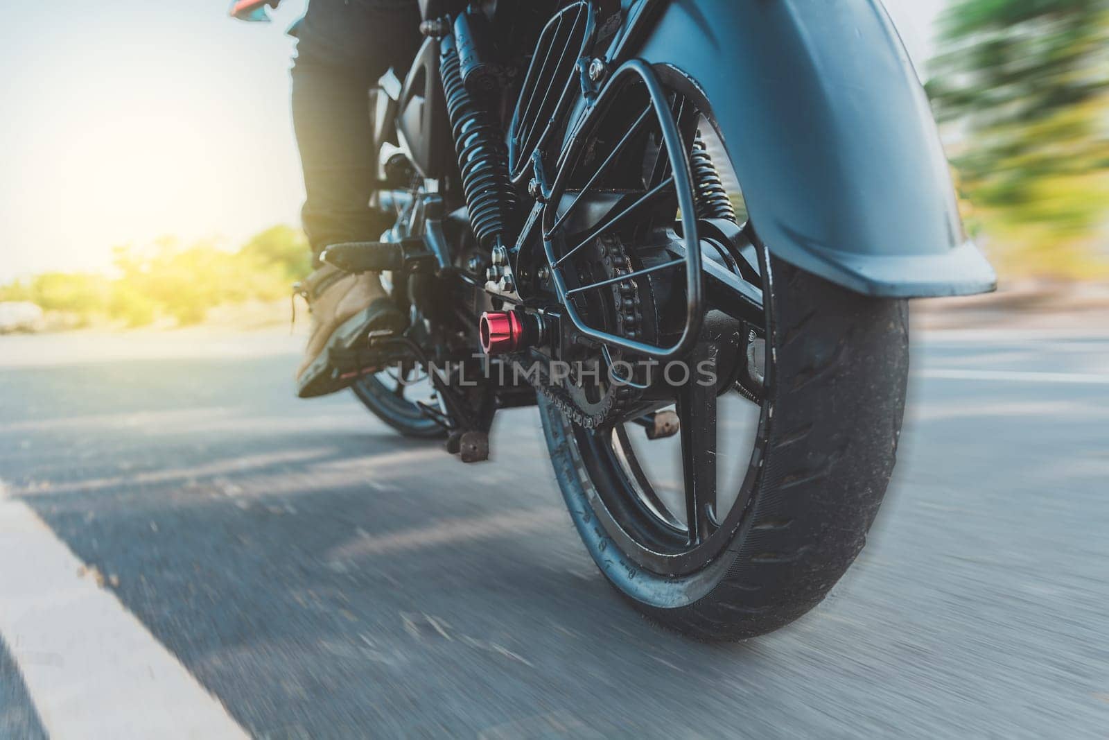Low angle view of a motorcyclist riding motorcycle. Close up of motorcyclist feet on his motorbike. Low angle view of a biker driving his motorbike by isaiphoto