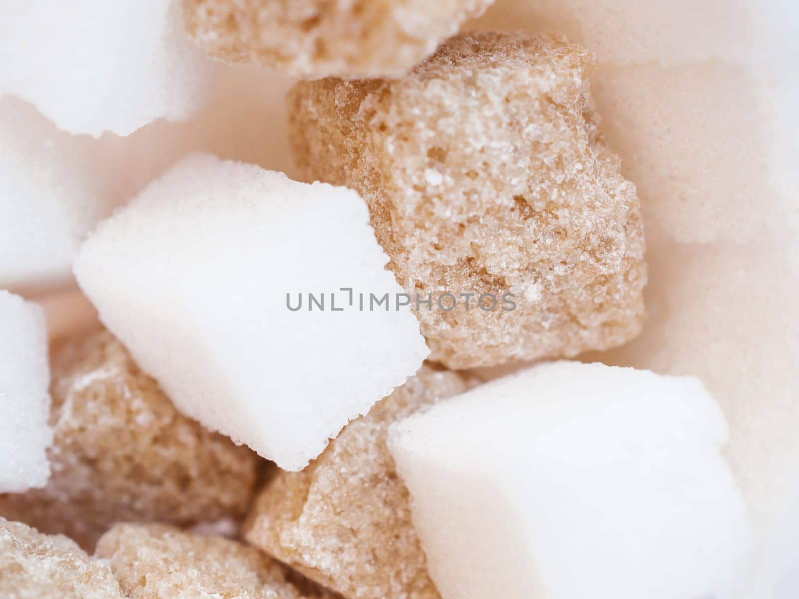 Macro view of mixed kind of lump sugar. Brown and white sugar cubes. Selective focus.