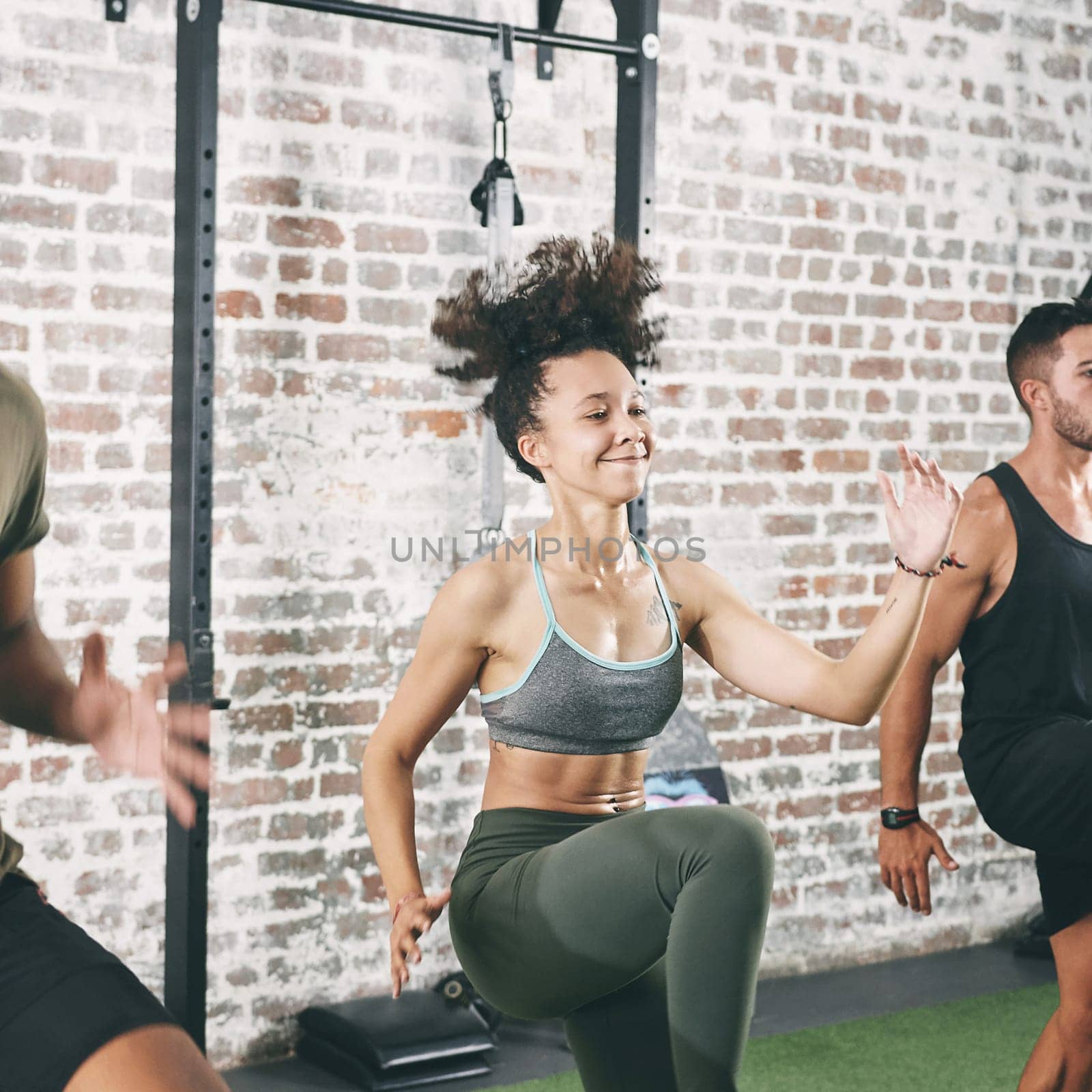 Im happy that I joined this class. a fitness group doing high knees while working out at the gym