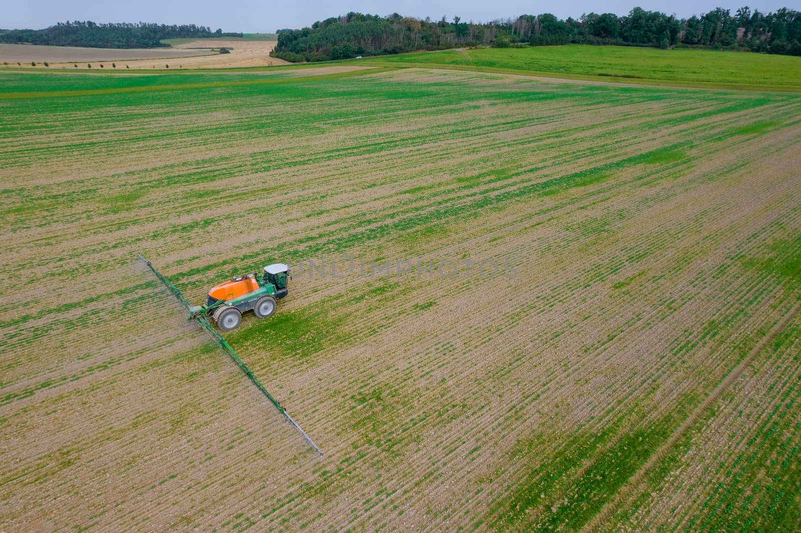 A tractor with a sprayer processes the field with fertilizer. Protection of grain crops from pests. Processing of the green field.