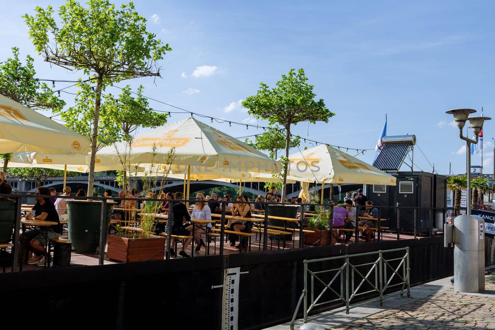 People or tourists sit on the terrace in the cafe drinking coffee and drinks and having lunch. Stay of tourists in the fresh air.