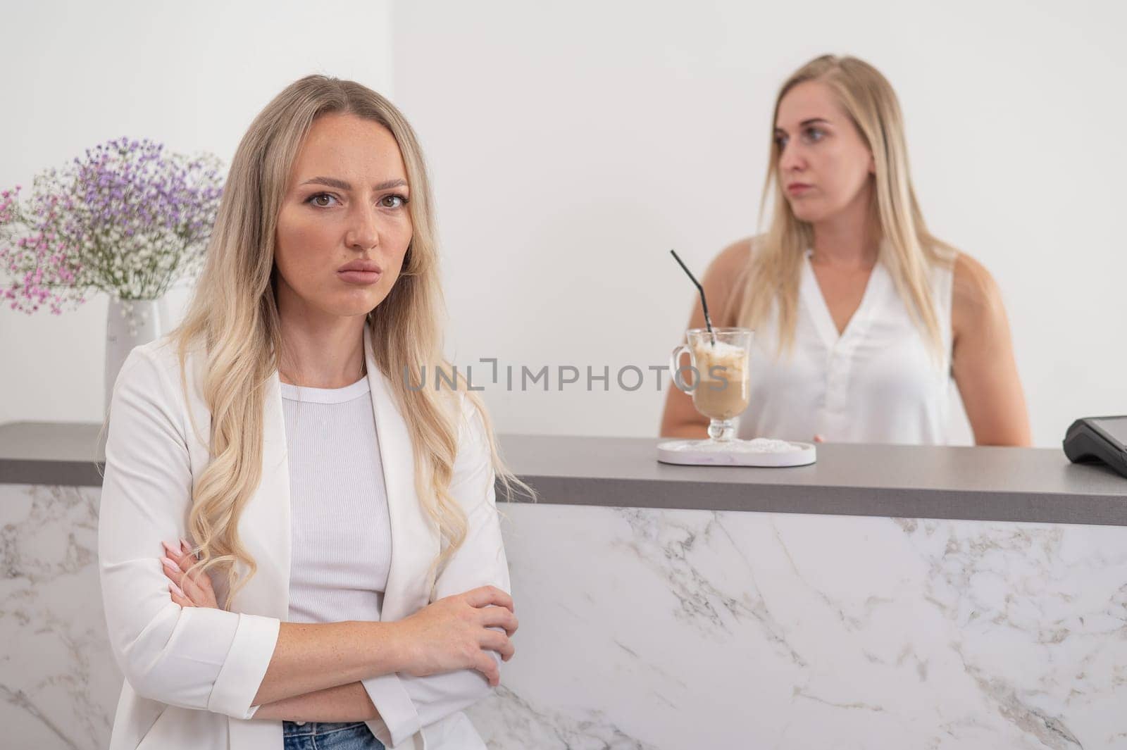 Dissatisfied client stands at the reception of a beauty salon. by mrwed54