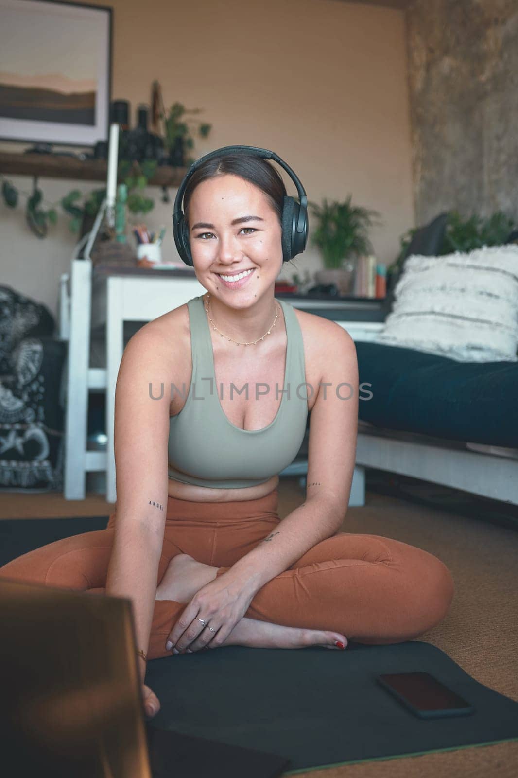 Technology helps me to progress in my workouts. Portrait of a young woman using a laptop while exercising at home. by YuriArcurs