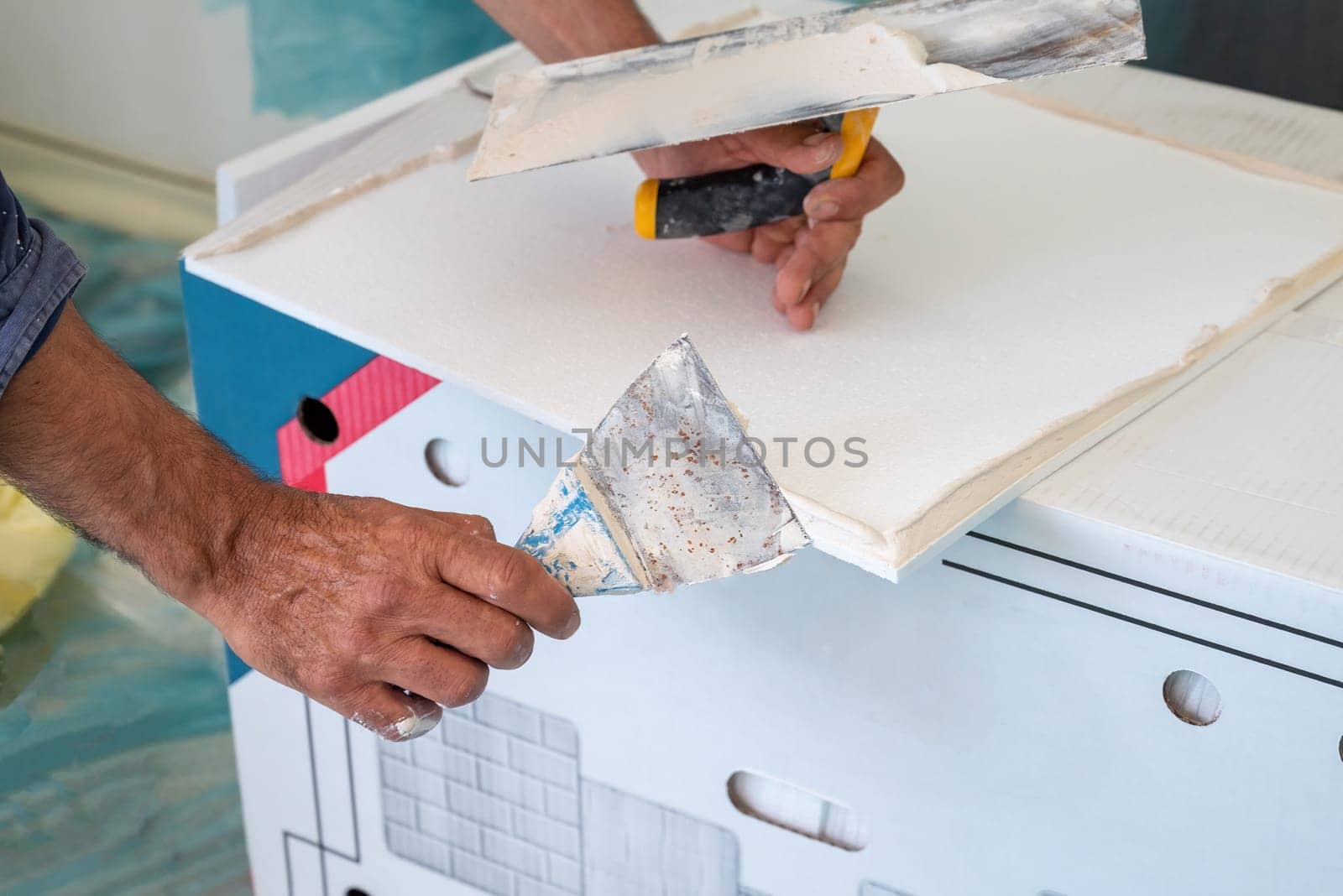 adhesive plaster application of styrofoam ceiling tiles of a home kitchen