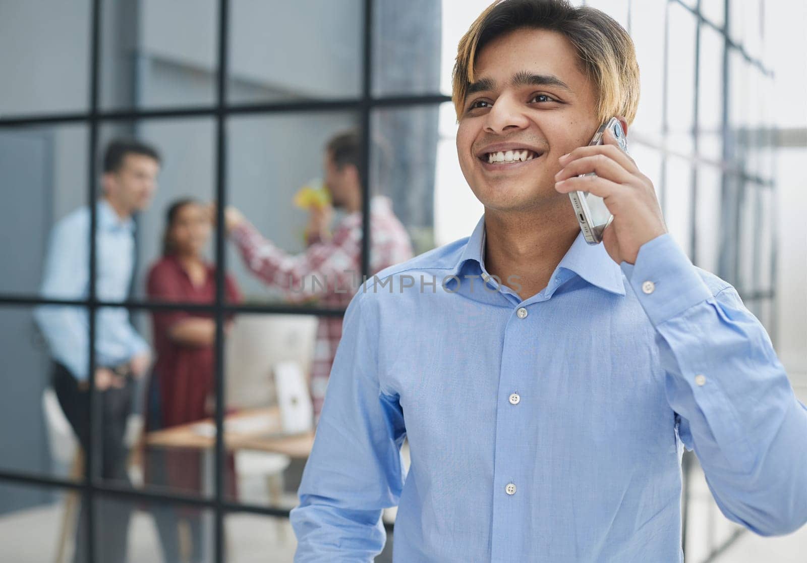 young man looking away while talking on the phone.