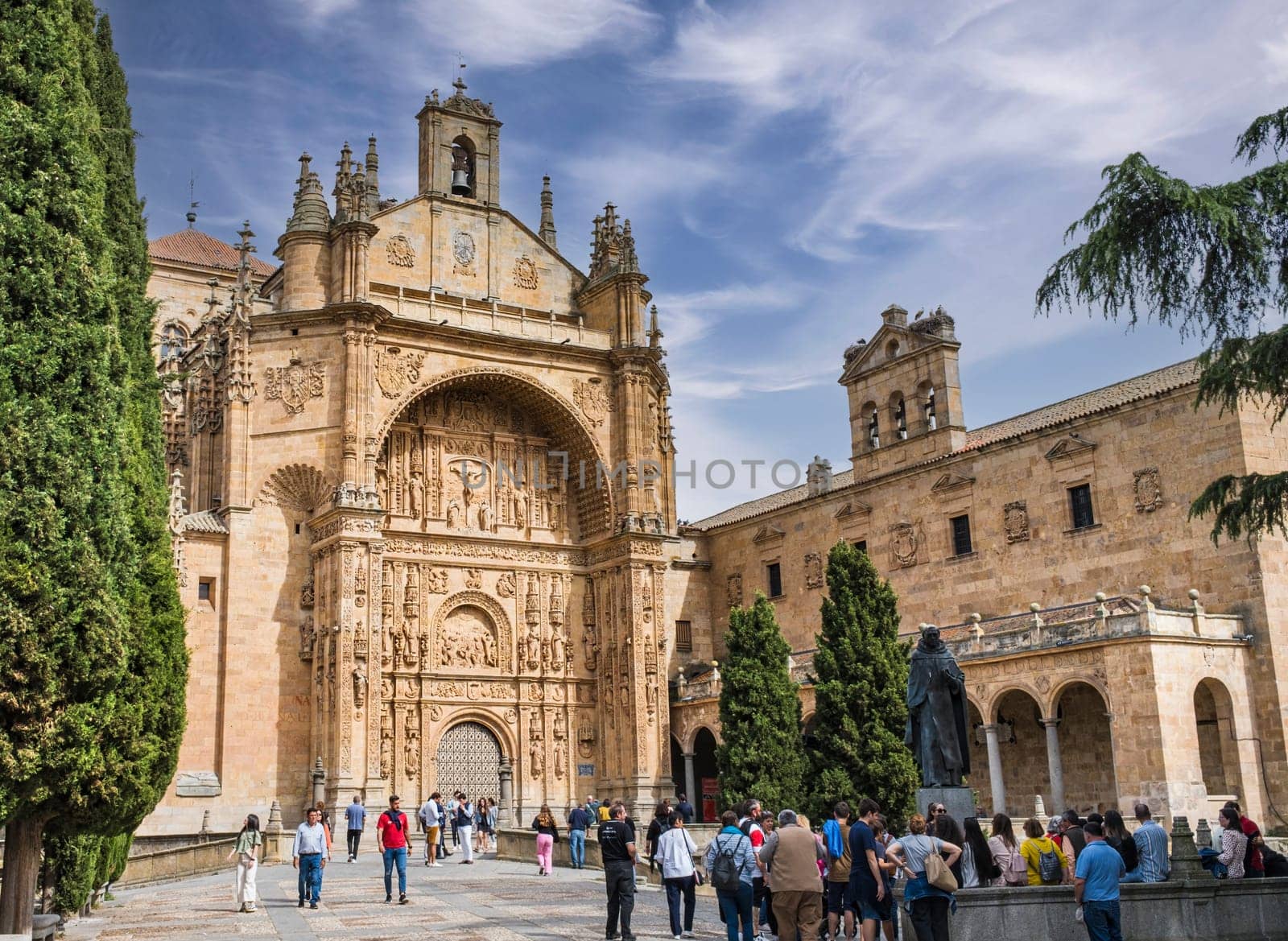 Highly ornamented frontal with bas-reliefs of the Church of San Esteban in the Castilian city of Salamanca, with tourists and on a sunny day.