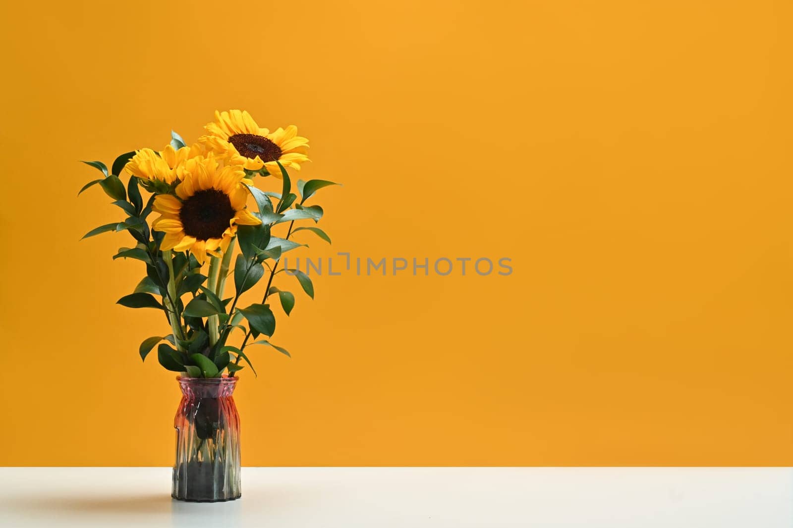 Sunflowers in vase over yellow background with copy space. Natural background, autumn or summer concept.