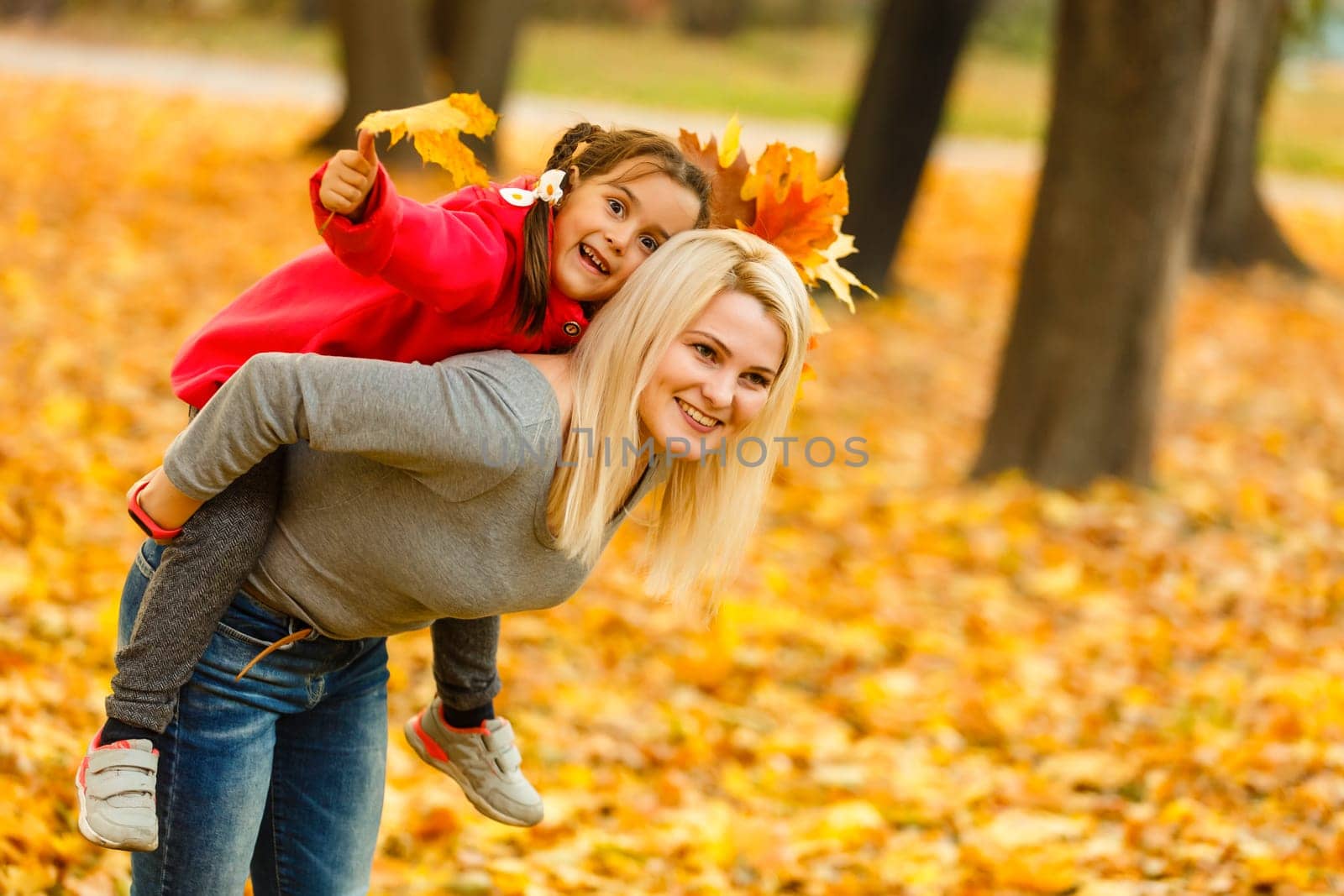 mother and daughter in the city park in autumn having fun time