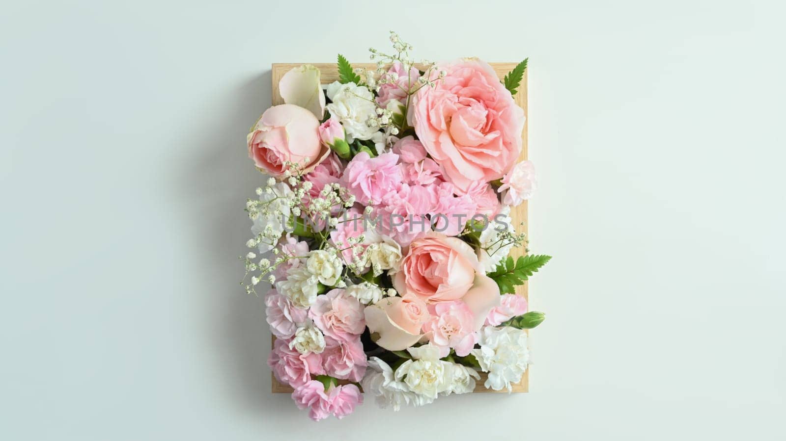 Wooden crate full of pastel colors flowers with pink rose and carnation on white background by prathanchorruangsak