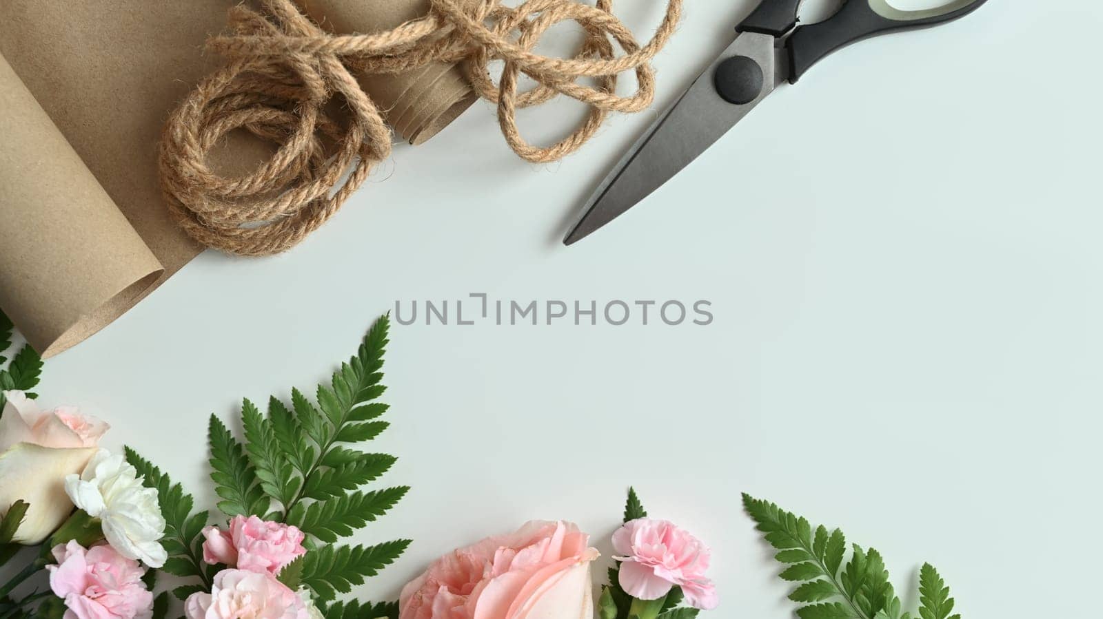 Florist equipment with fresh flowers on white background. Flat lay, top view with copy space.