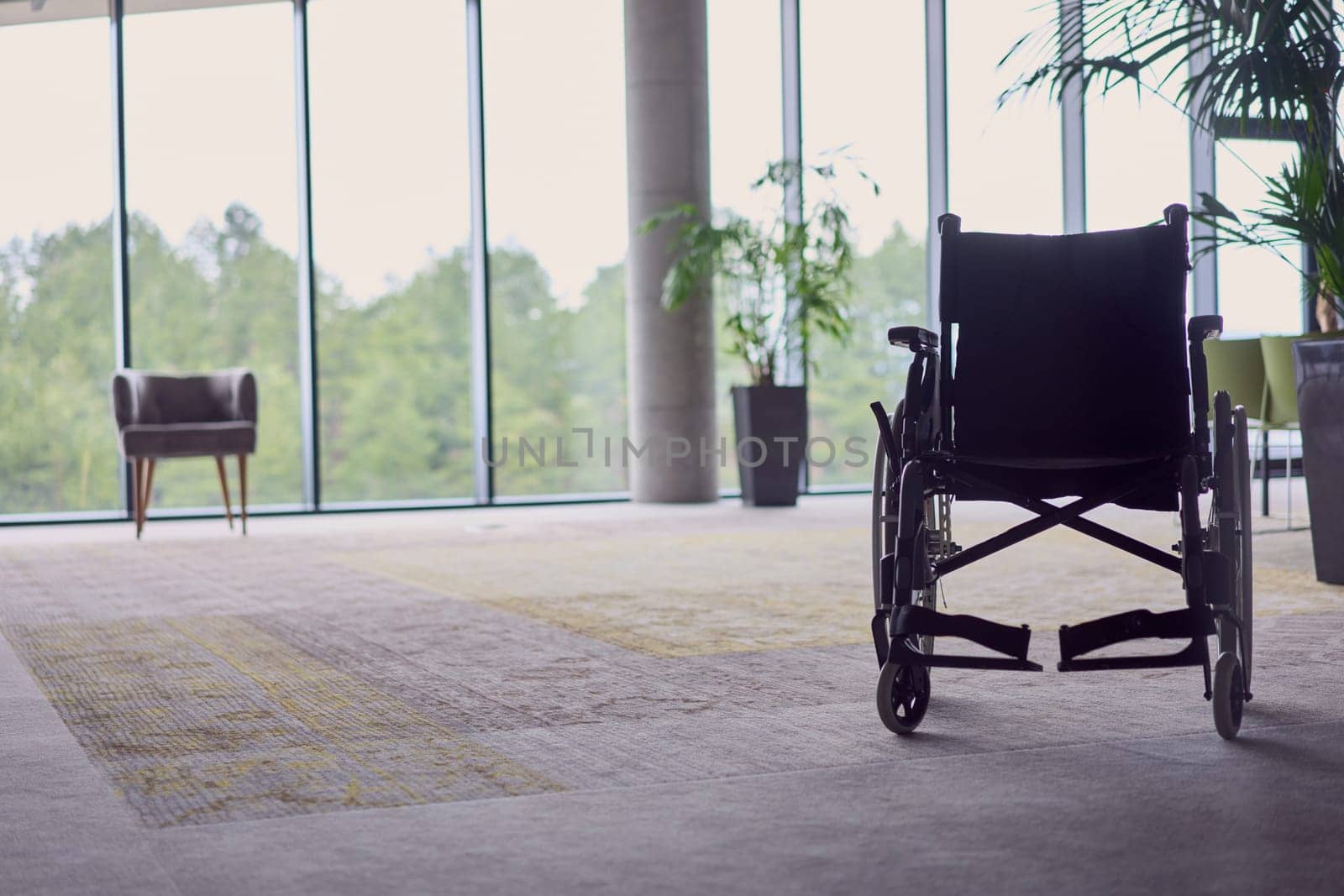 A wheelchair in a modern, spacious office, symbolizing inclusivity and accessibility for business meetings. by dotshock