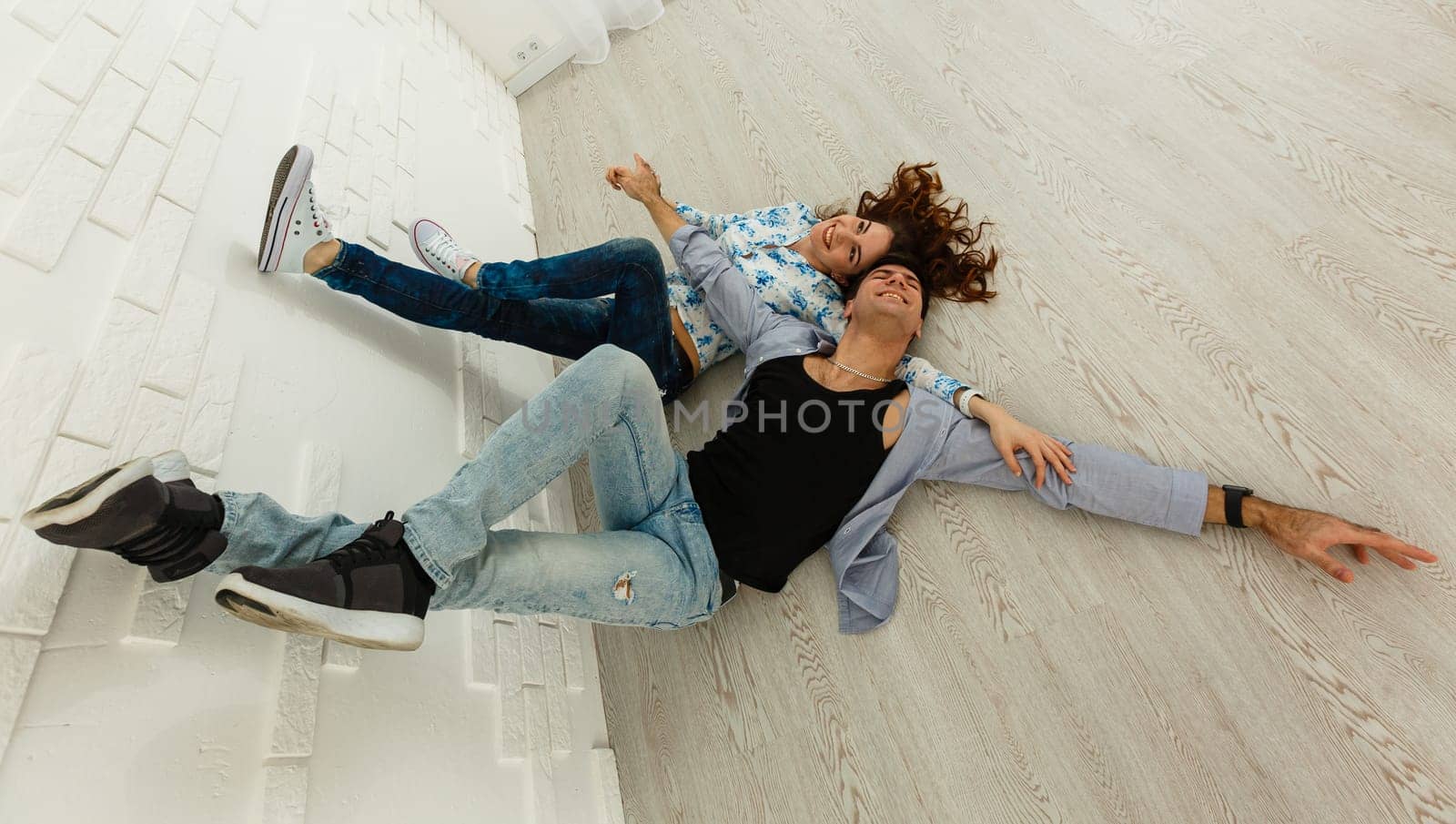 Happy couple grimacing. Cheerful young man and woman fooling around in studio on white background