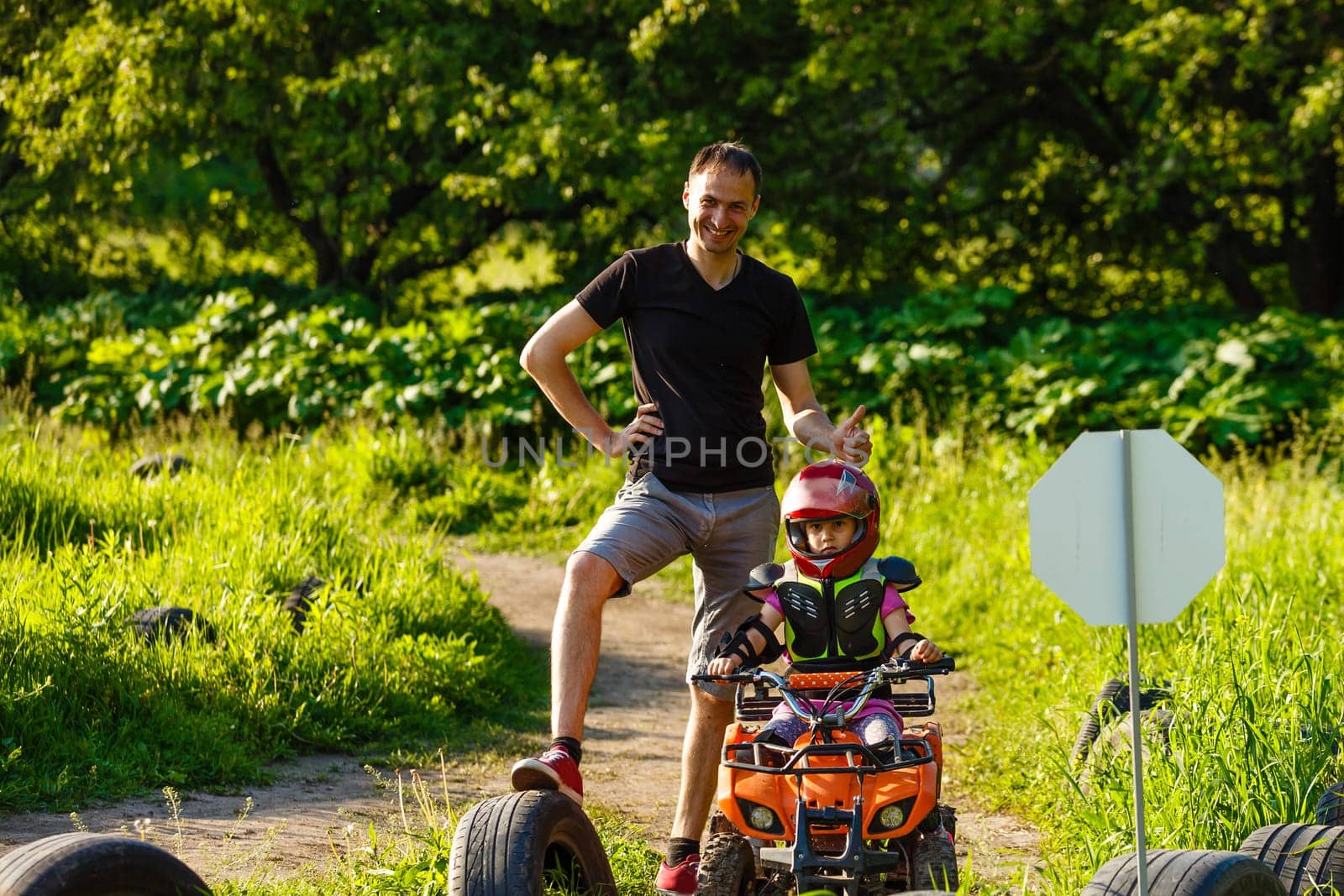 A child rides a quad bike through the mud. ATV rider rides.