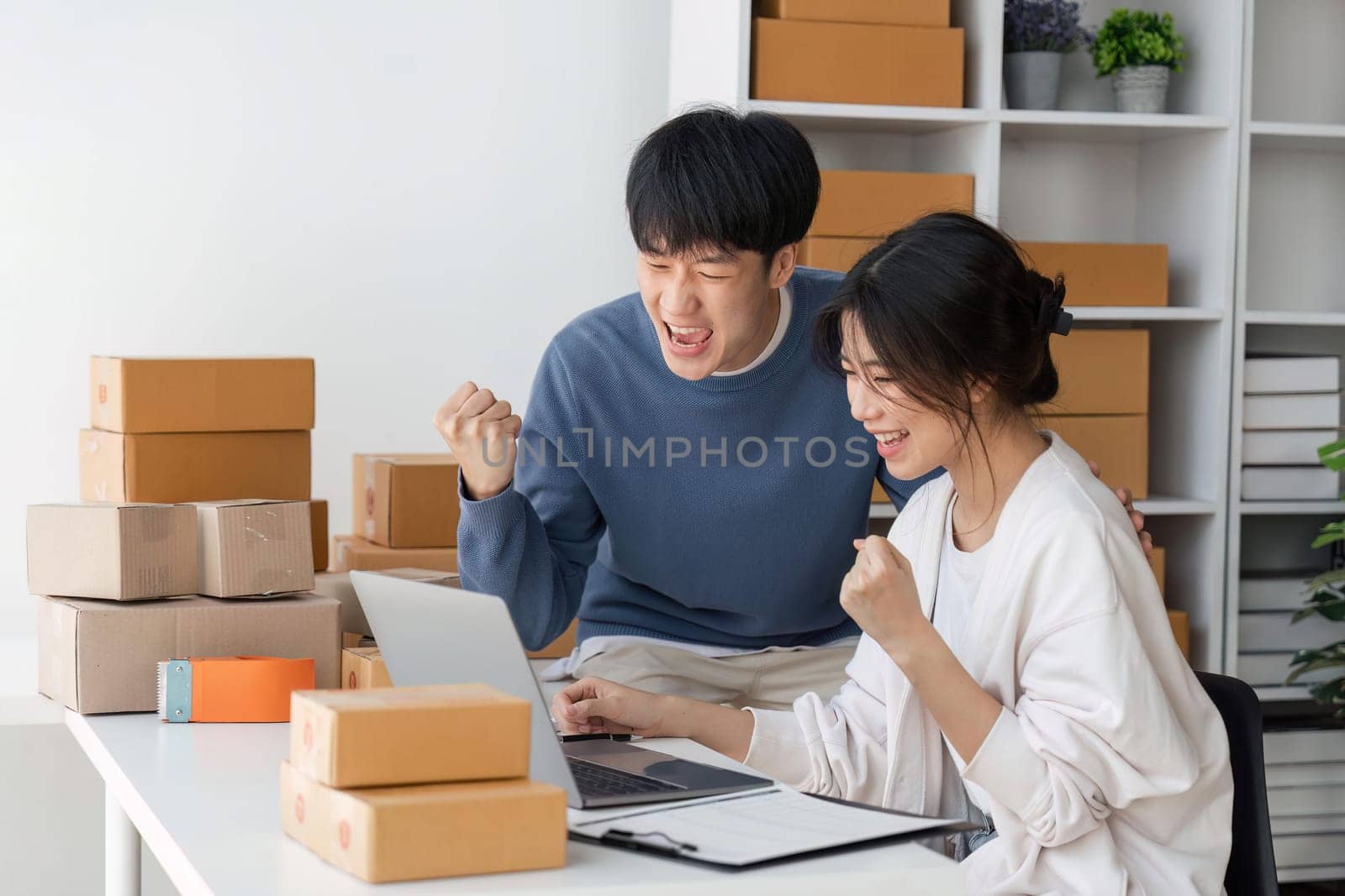 Image of Asian Happy couple people working in home. They are happy and success with their online store. Concept of freelancer startup and online business.