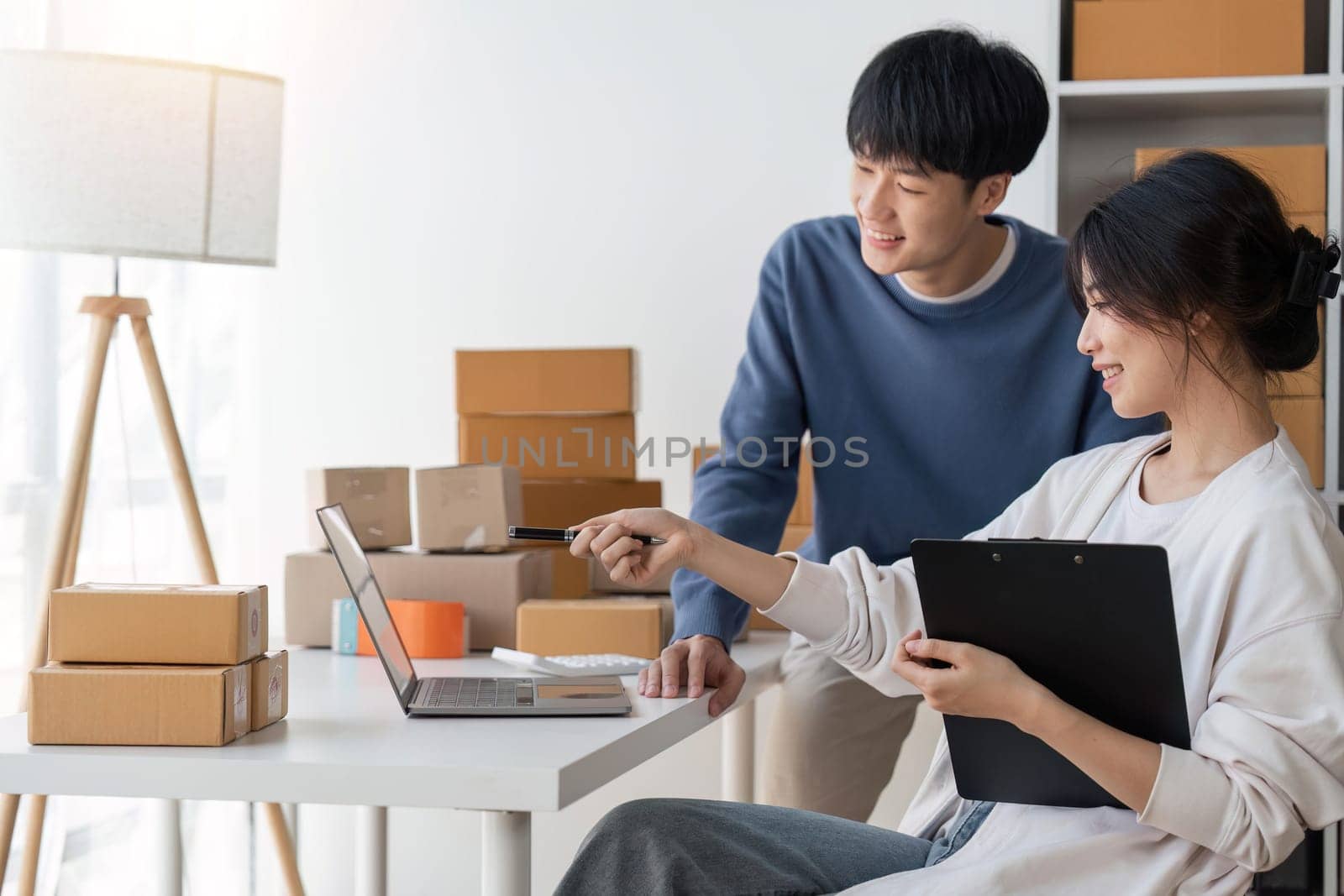 Image of Asian Happy couple people working in home. They are happy and success with their online store. Concept of freelancer startup and online business.