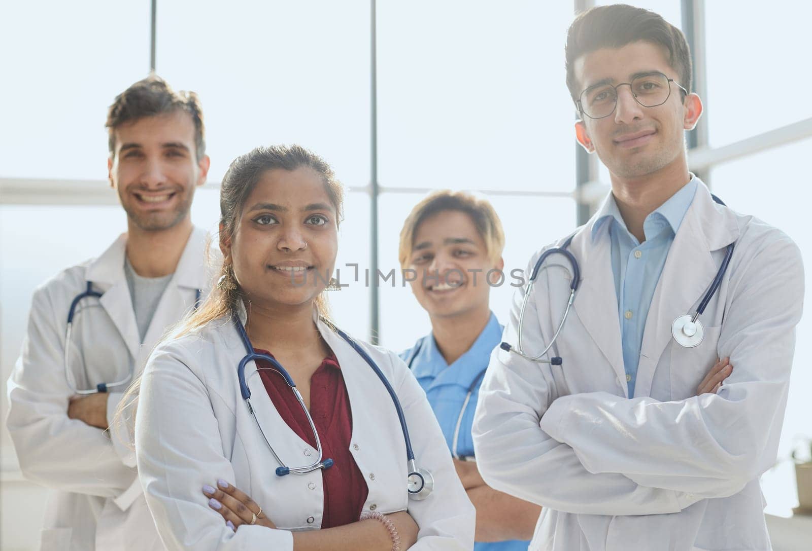 Professional multiethnic doctors posing standing in hospital corridor