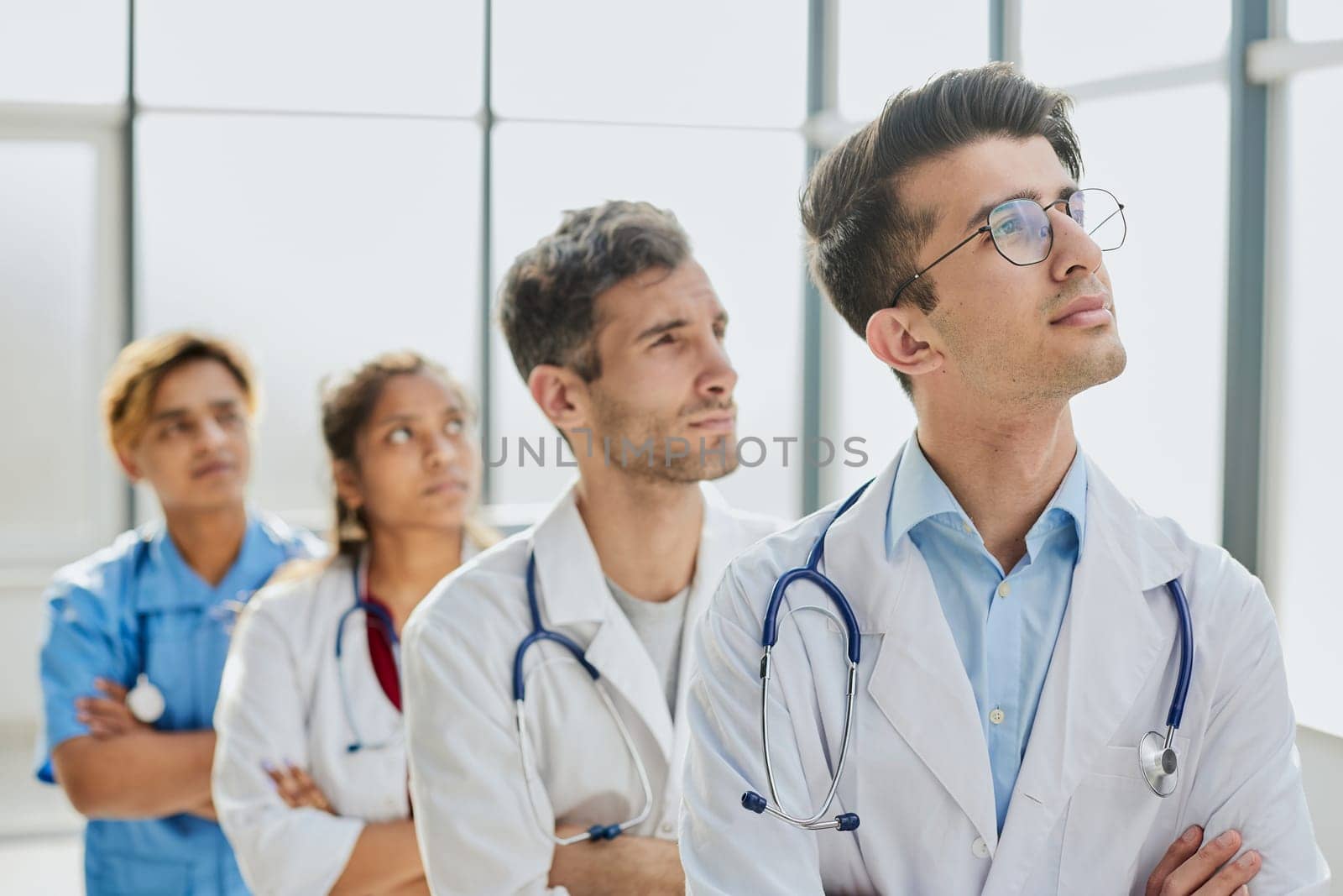 multiethnic physicians standing with crossed arms and smiling at camera