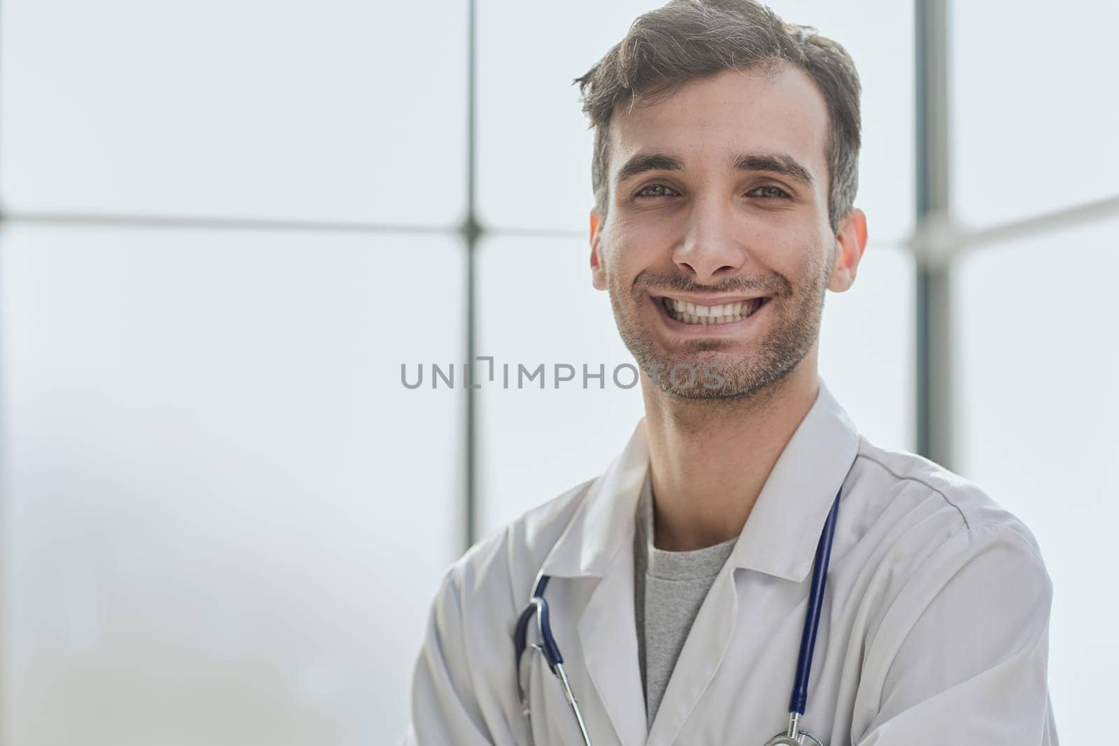 man smiling and looking at camera, doctor student intern with stethoscope