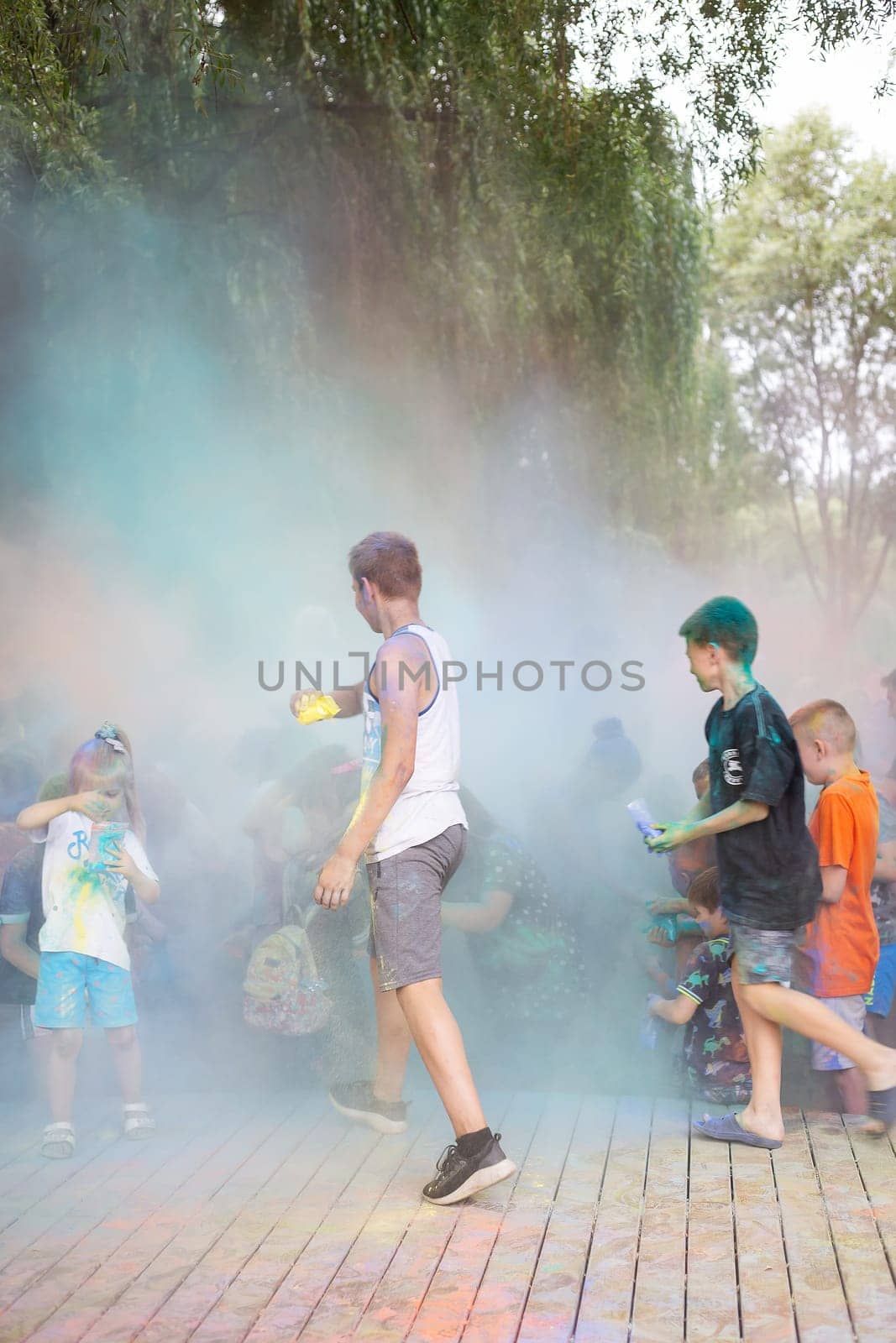 Lviv, Ukraine - July 18, 2021: Color Holi Festival, a crowd of people adults and small children throw colorful paint. Indian holiday. by sfinks