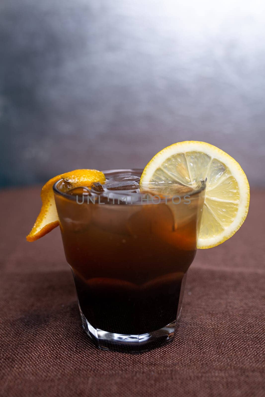 alcoholic drink with Cola and a slice of lemon in a glass.