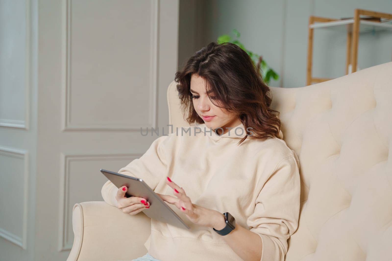 Attractive young successful businesswoman reading employee reports study working via digital tablet