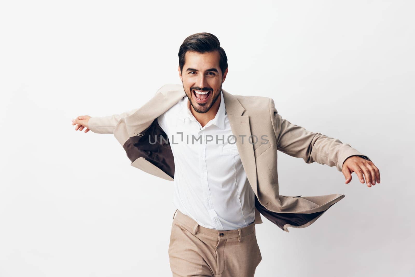 smiling man suit beige businessman victory business winner running hand happy by SHOTPRIME