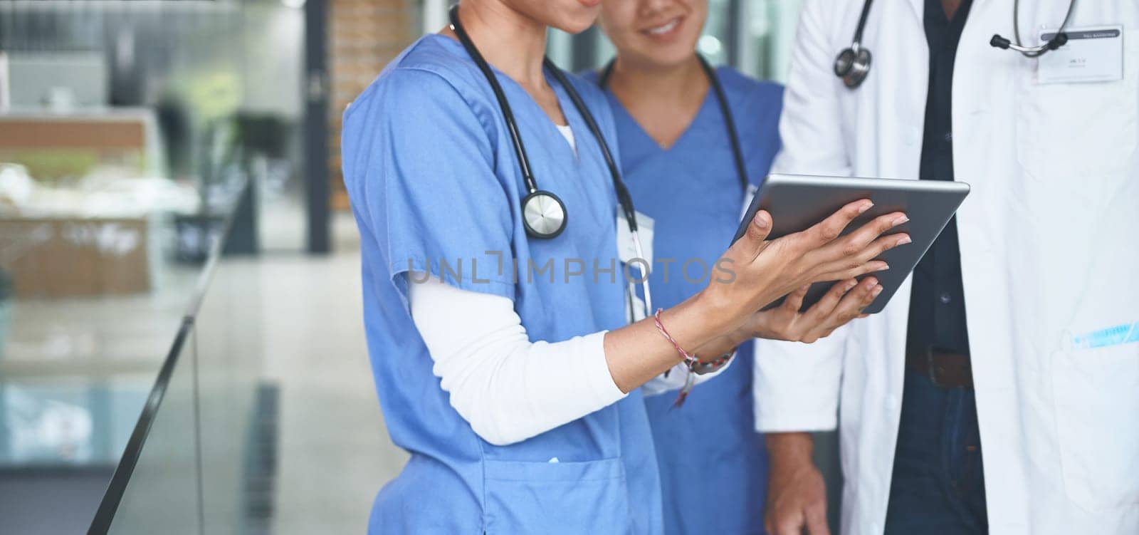 Can you have a look at these results. an unrecognizable doctor standing with his nurses and using a digital tablet during a discussion. by YuriArcurs