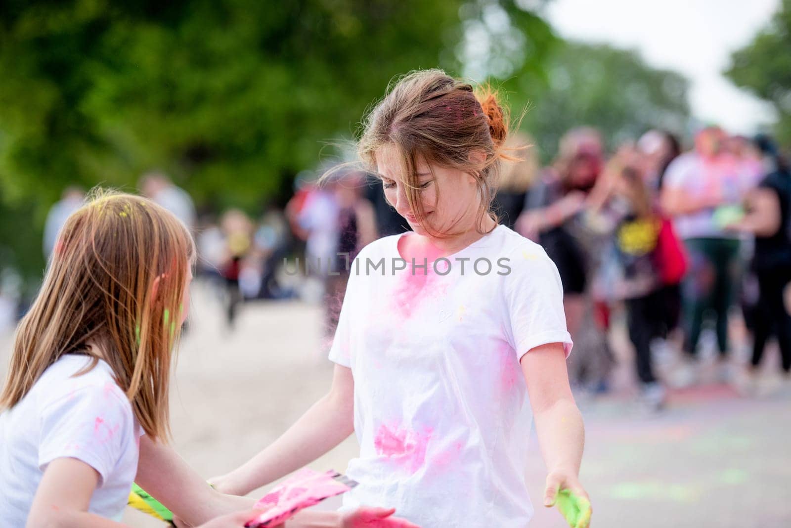 Pretty sisters in indian traditional Holi festival with colorful powder having fun. Female teenager and preteen child friends enjoying holiday