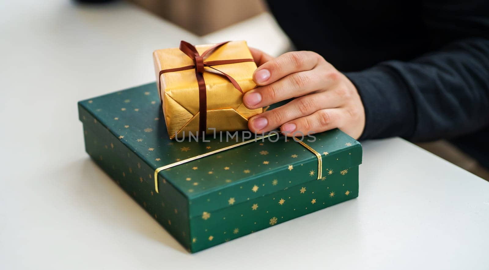 Male hands hold gifts in beautiful wrapping paper closeup view, a man prepares gifts for his loved one, relatives, friends and family for celebration the holiday.