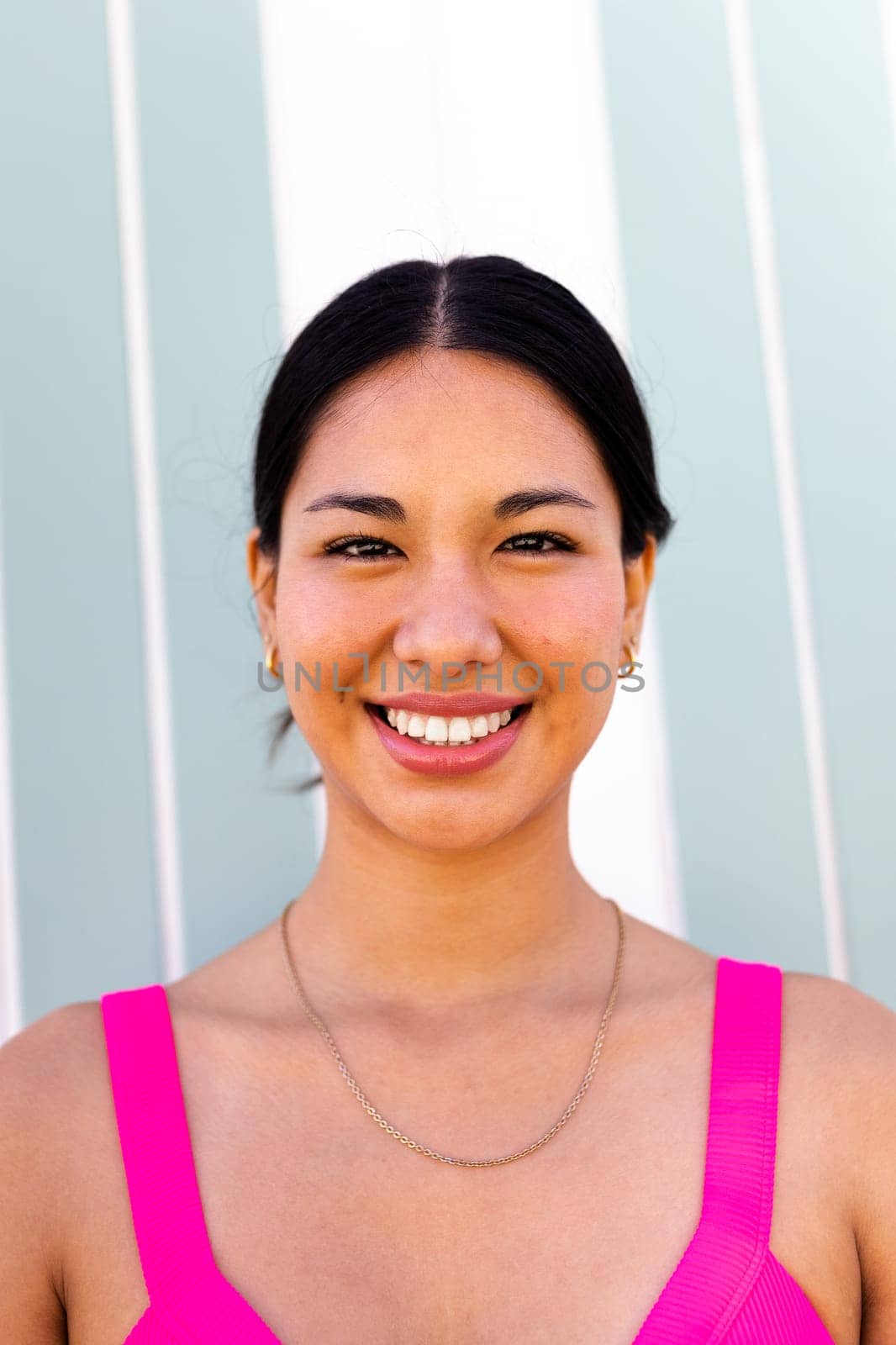 Headshot of young happy hispanic woman on vacation looking at camera by Hoverstock