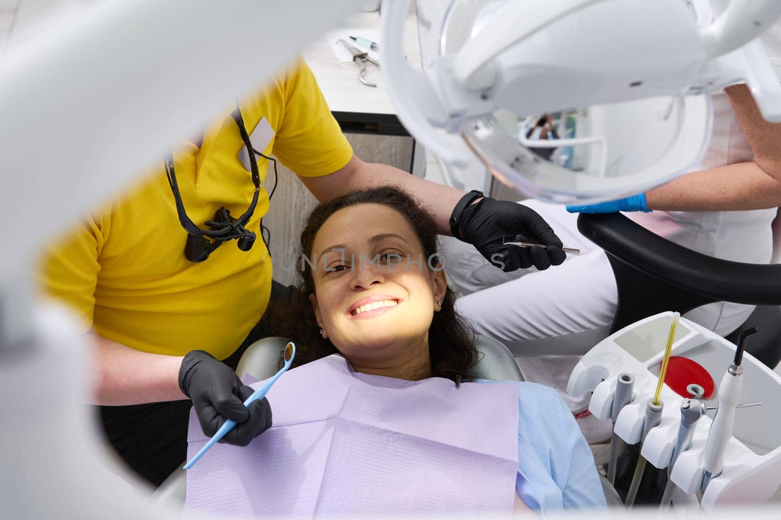 Close-up portrait of a smiling young pregnant woman in dentist's chair getting a dental consultation in dentistry clinic. Pregnancy. Dental health and oral cavity care concept. Doctor treats teeth.
