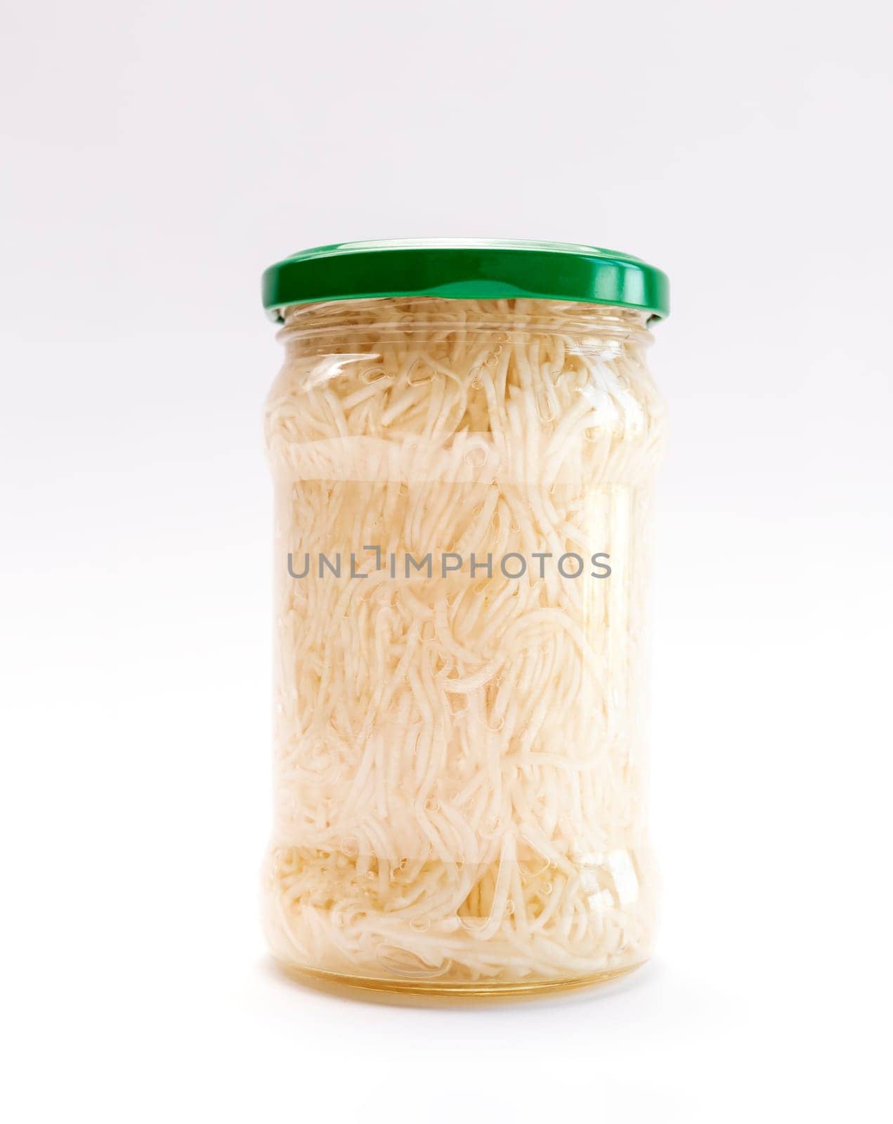 Isolated Celery Root Salad Preserve In Glass Jar With Screw Metal Cap On White Background. Shredded And Pickled Celery Crops, Tuber. Apium Graveolens, Culinary. Vertical Plane.