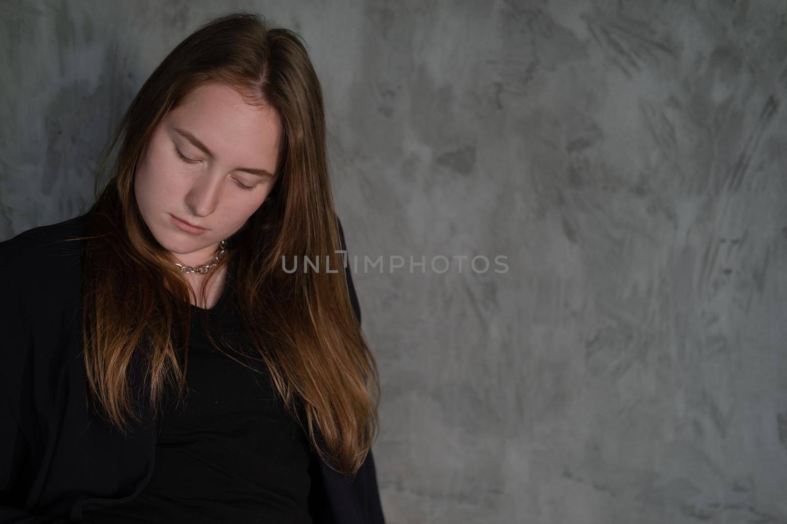 portrait of confident woman in black in dark room. pensive serious people. business woman. feminine. millennial people.