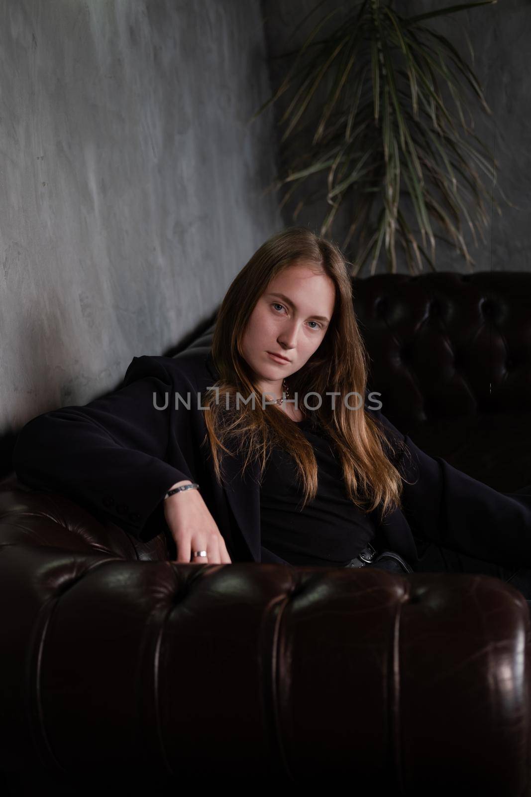 portrait of confident woman in black in dark room. pensive serious people. business woman. feminine. millennial people.