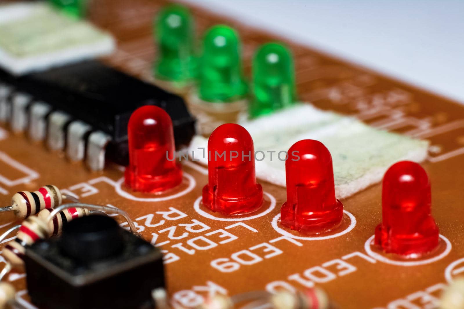 Red and green light bulbs on electronic device board close up