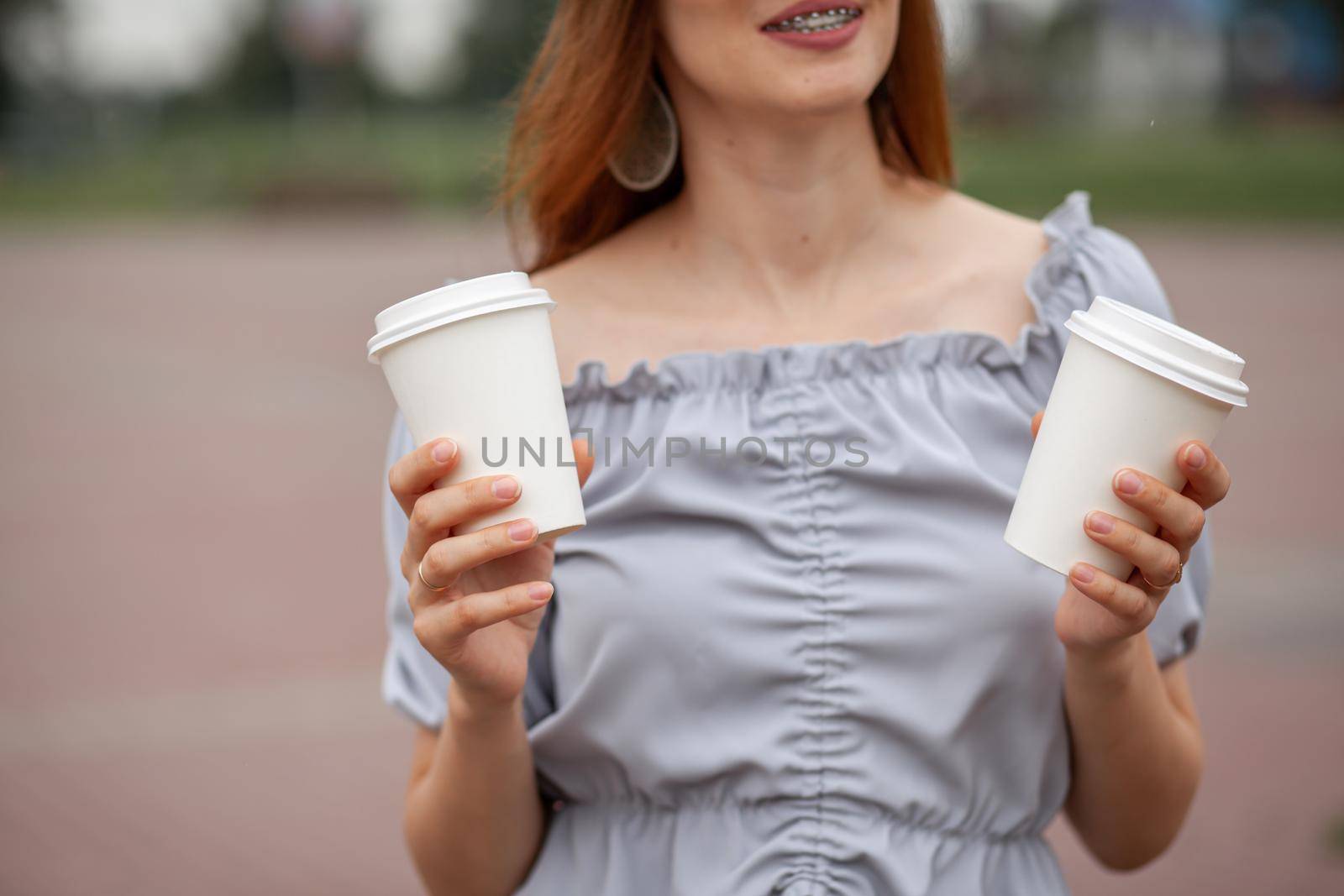 Two white paper cup with coffee in woman hand. Time for drink coffee in city. Coffee to go. Enjoy moment, take a break. Disposable paper cup closeup. Delicious hot beverage. Blank space for text,