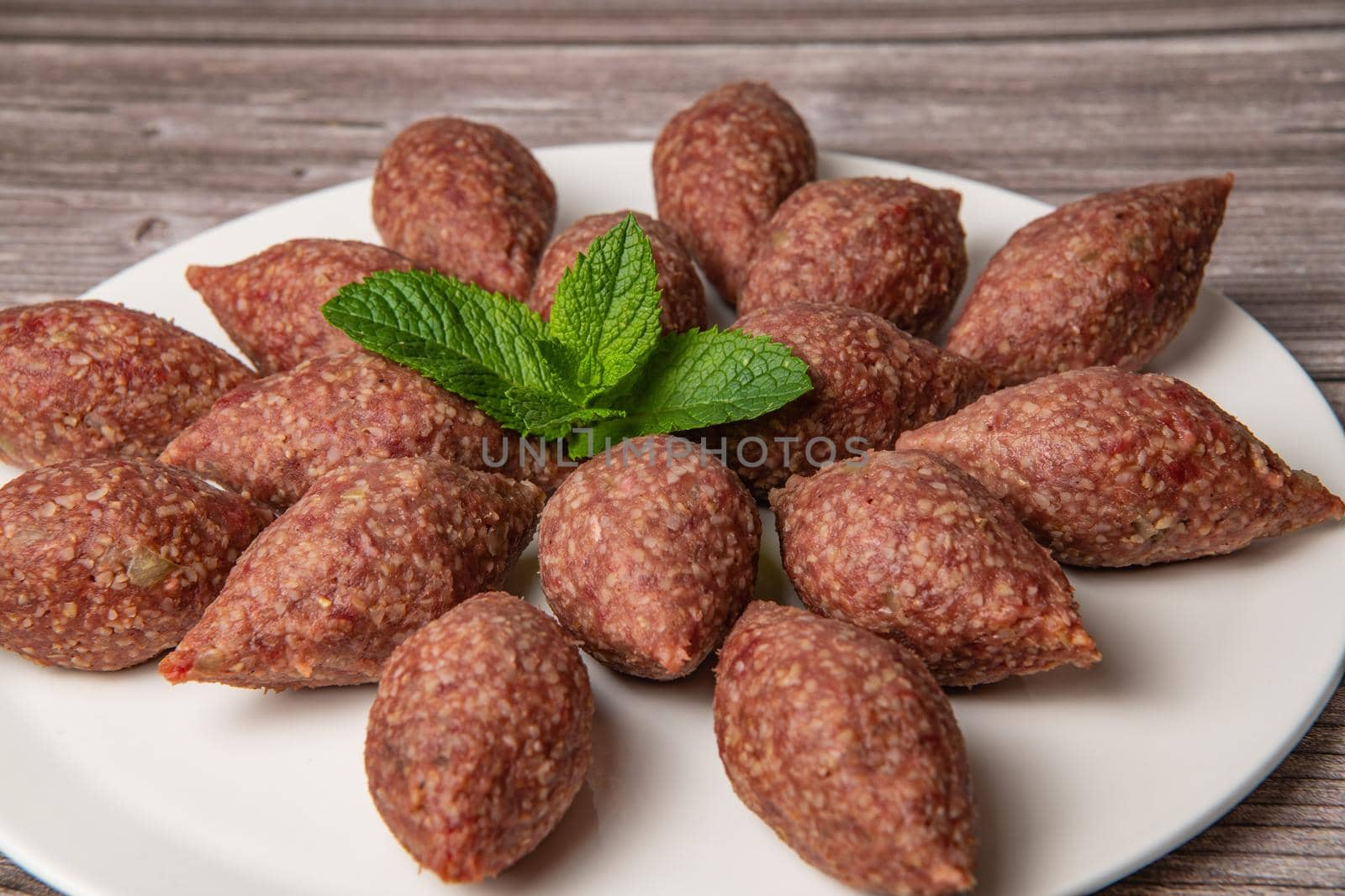 Traditional kebbe and pita bread on big round plate in lebanese restaurant. High quality photo