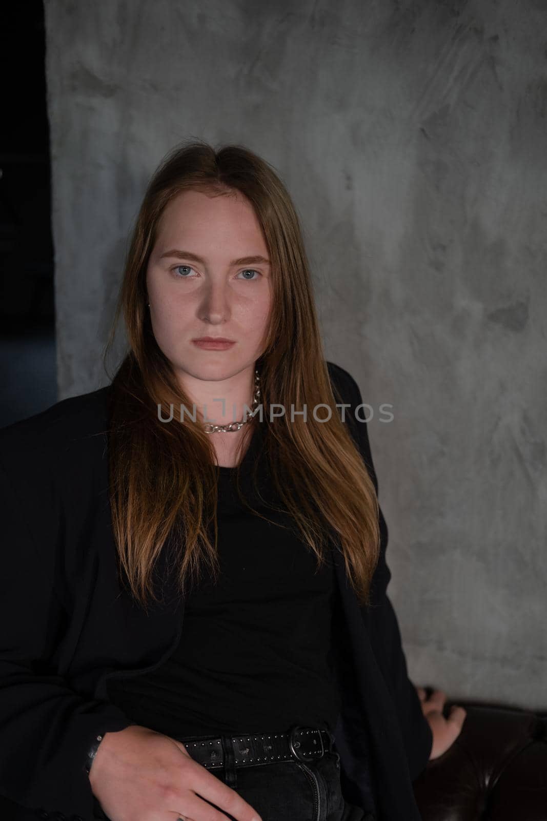 portrait of confident serious brunette woman in black clothes on dark background. femininity.