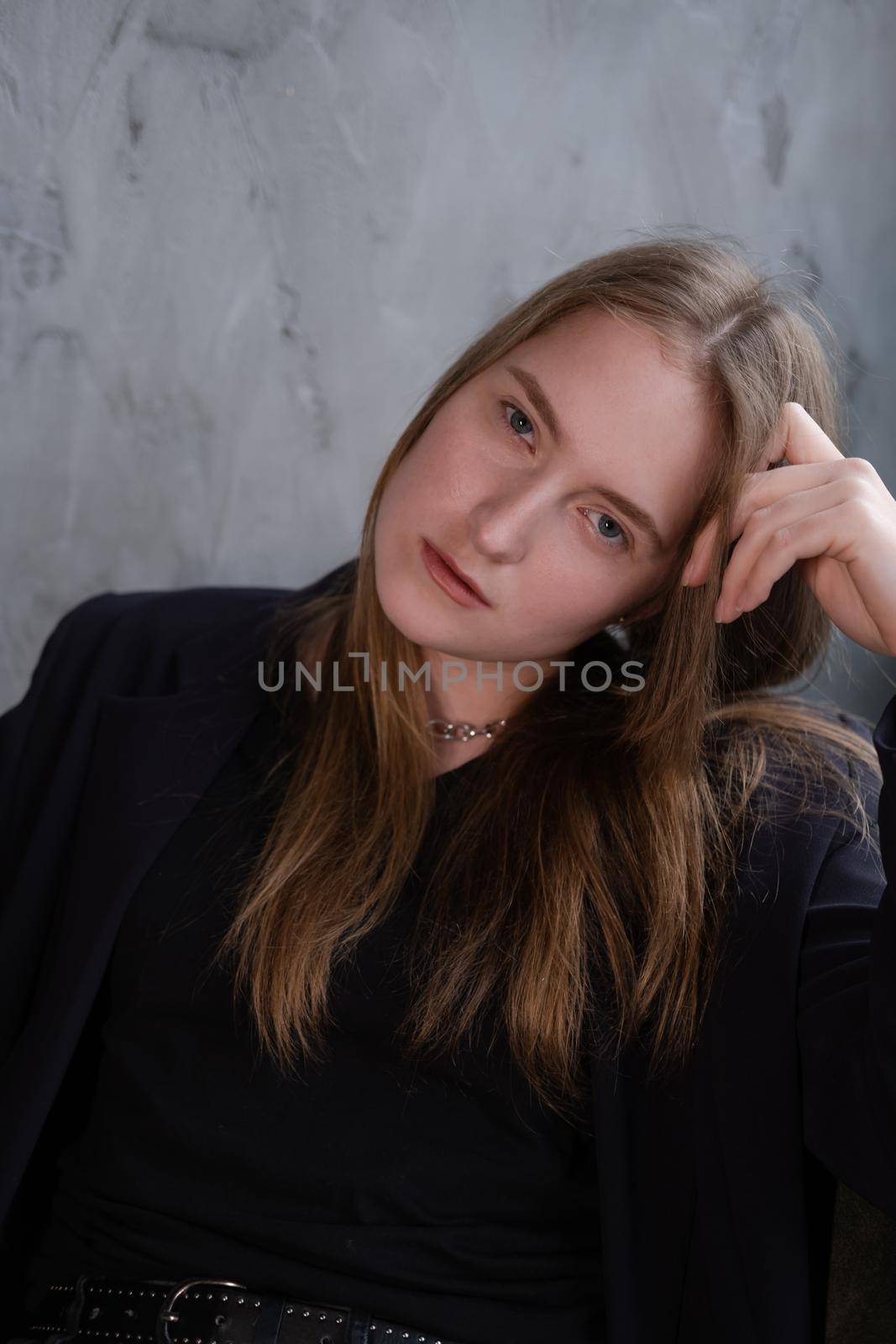 portrait of confident serious brunette woman in black clothes on dark background. femininity.