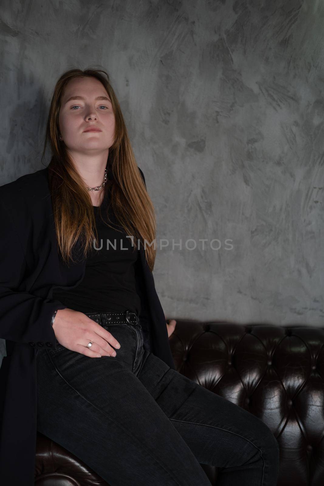 portrait of confident woman in black in dark room. pensive serious people. business woman. feminine. millennial people.