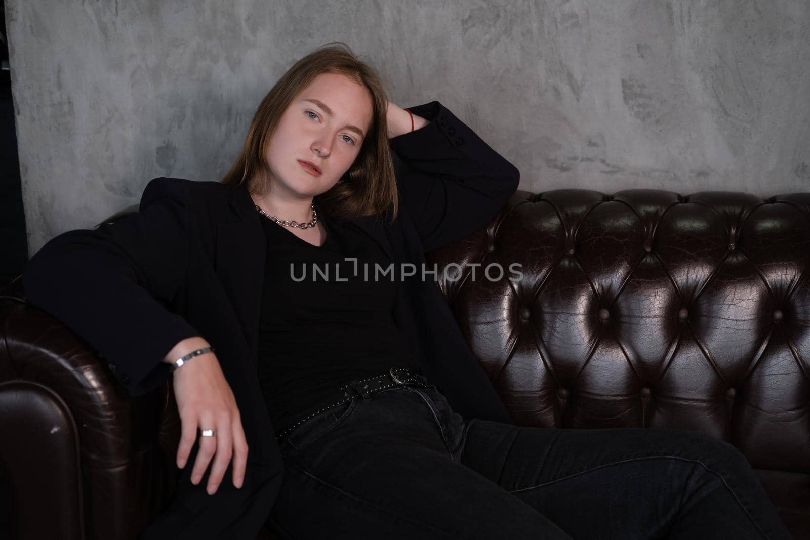 portrait of confident serious brunette woman in black clothes on dark background. femininity.