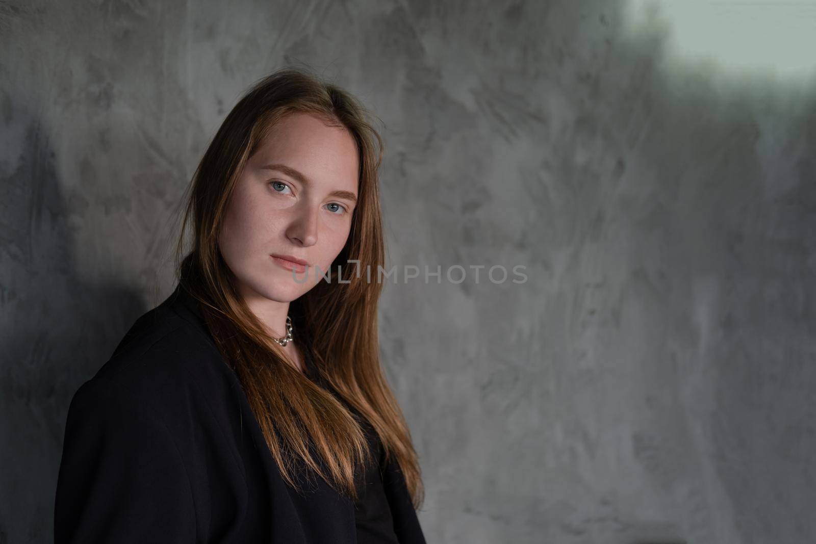 portrait of confident serious brunette woman in black clothes on dark background. femininity by oliavesna